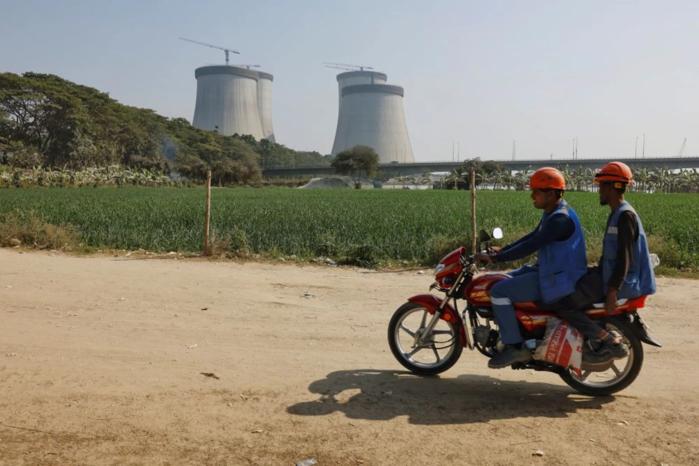 Two people pass by on a motorcycle as Rooppur Nuclear Power Plant, in Ishwardi upazila of Pabna District, west of Dhaka, Bangladesh, February 14, 2023.
