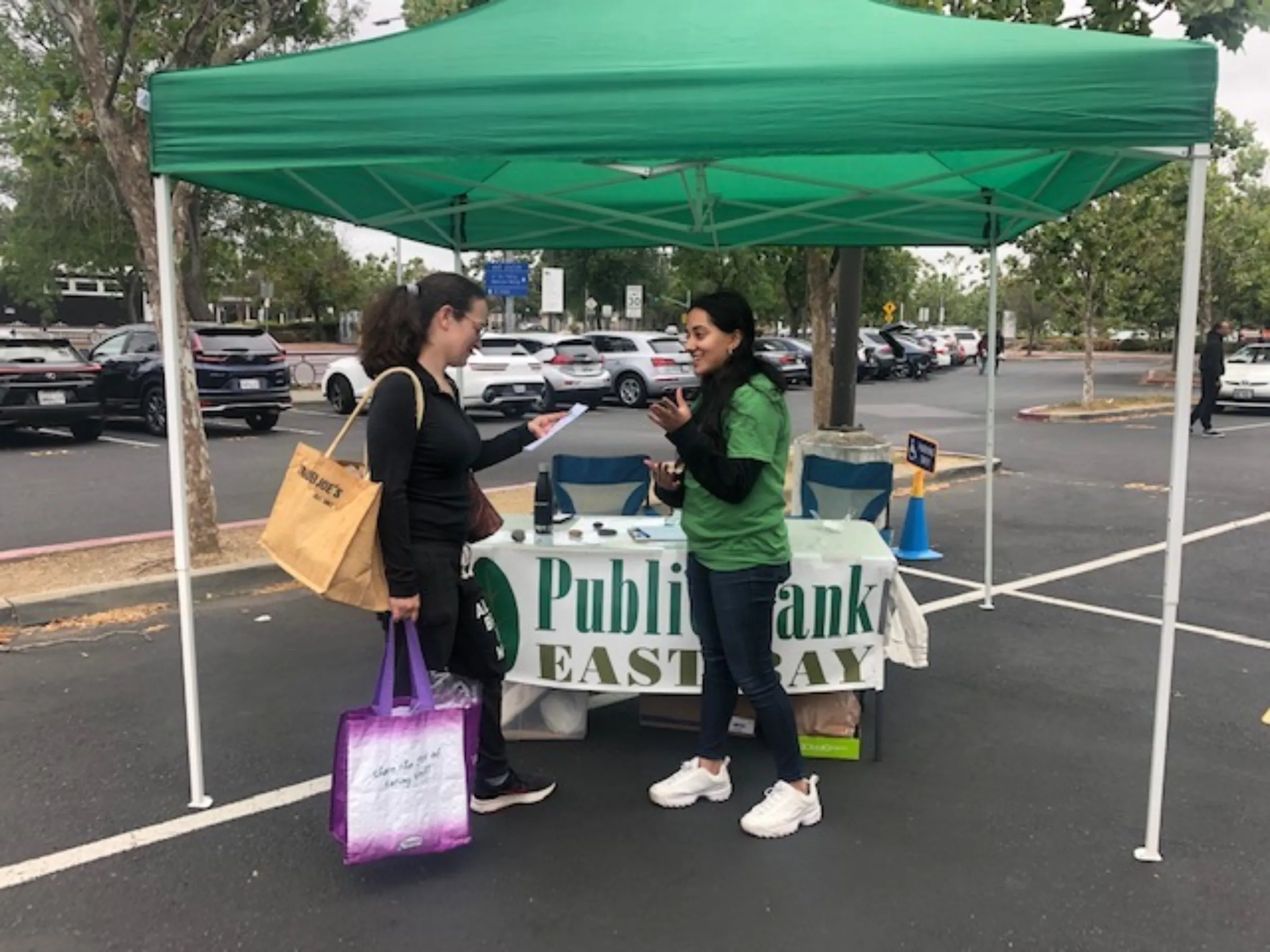 People discuss a public bank proposal in July 2022 at a farmers market