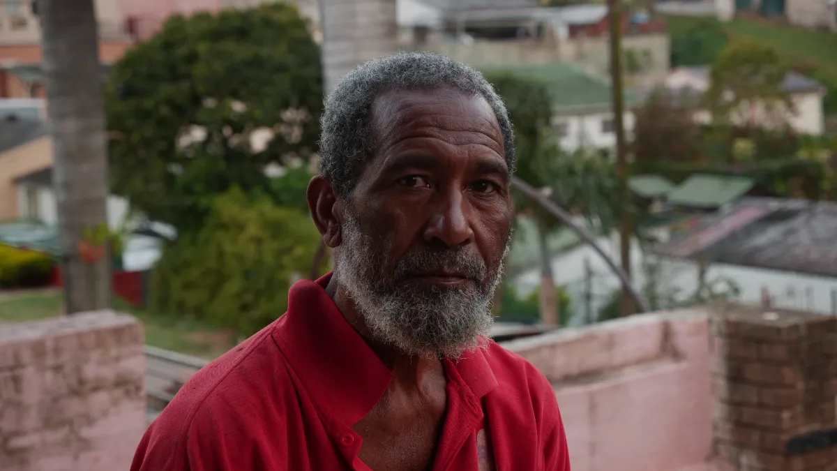 Alpha Franks, an elderly member of the Makua community, looks at the camera from his home in Chatsworth.