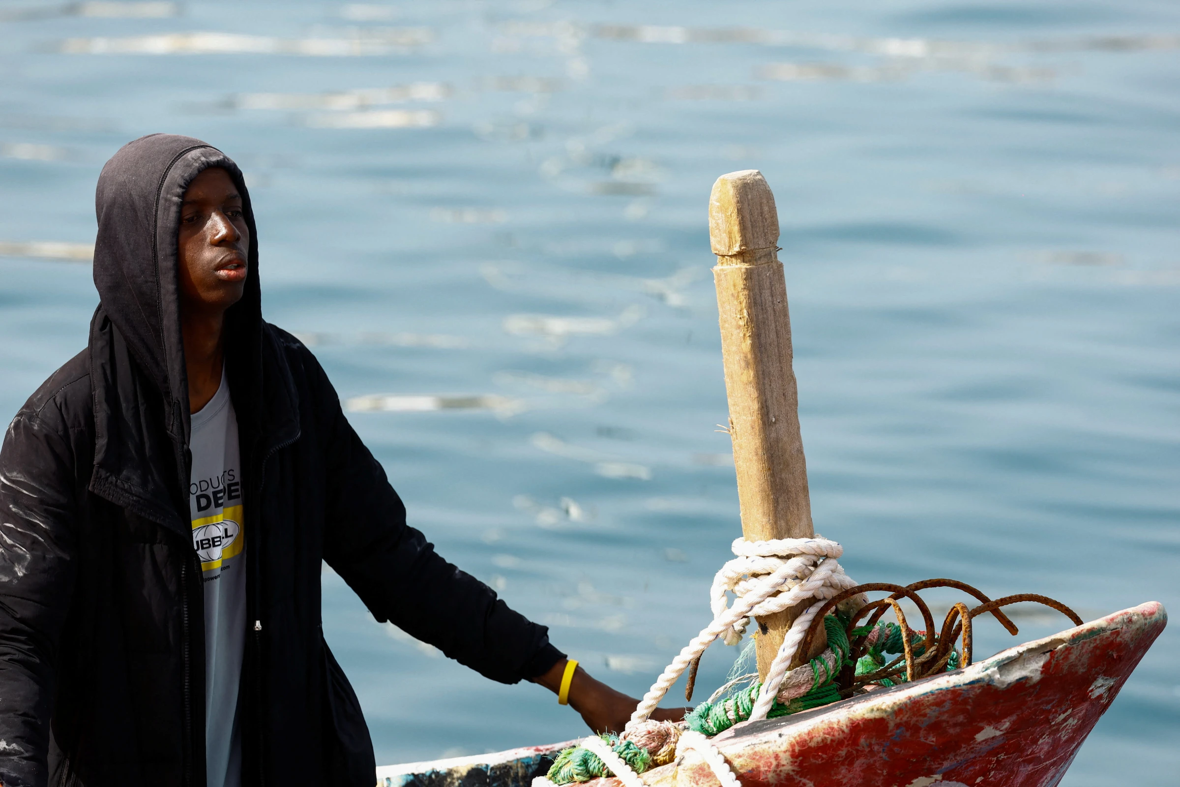 A migrant waits to disembark from a fiber boat in the port of Arguineguin, on the island of Gran Canaria, Spain, July 18, 2024. REUTERS/Borja Suarez