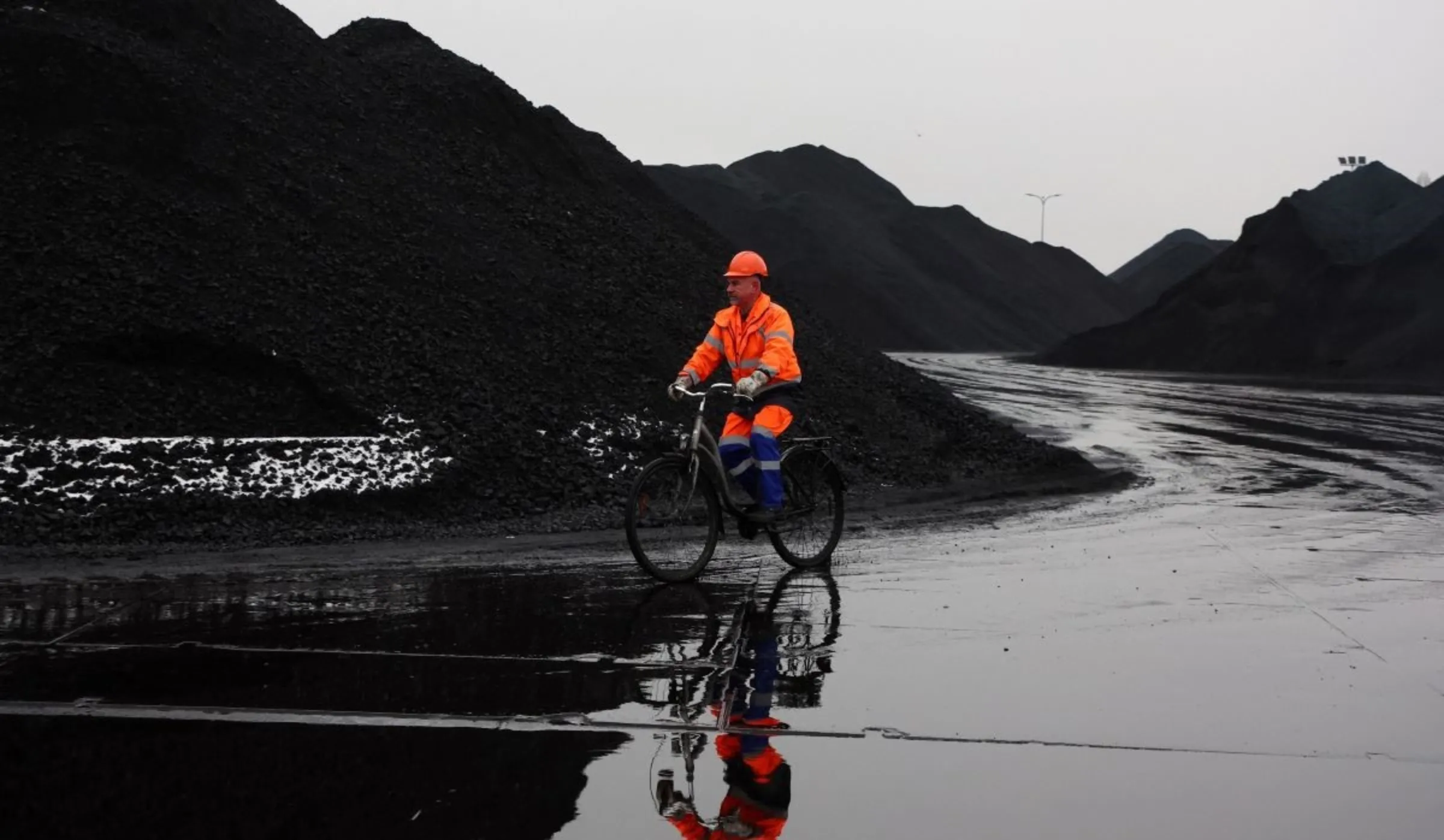 A man rides a bike through the coal storage in Port Gdanski Eksploatacja, Gdansk, Poland, December 5, 2022. REUTERS/Kacper Pempel