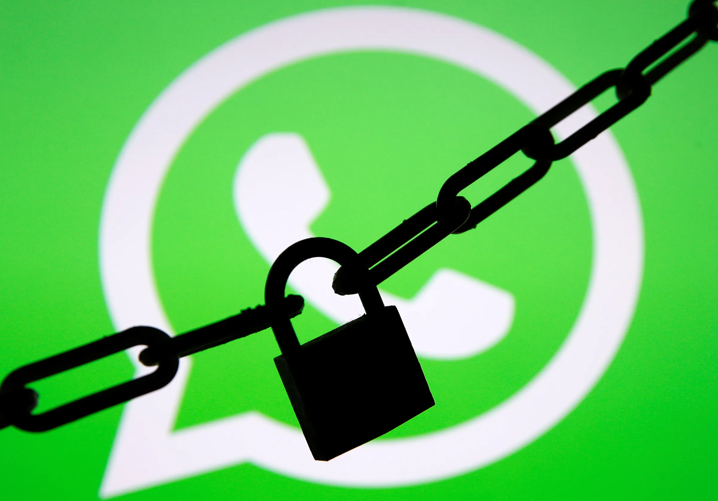 A photo illustration shows a chain and a padlock in front of a displayed Whatsapp logo January 13, 2017. REUTERS/Dado Ruvic/Illustration