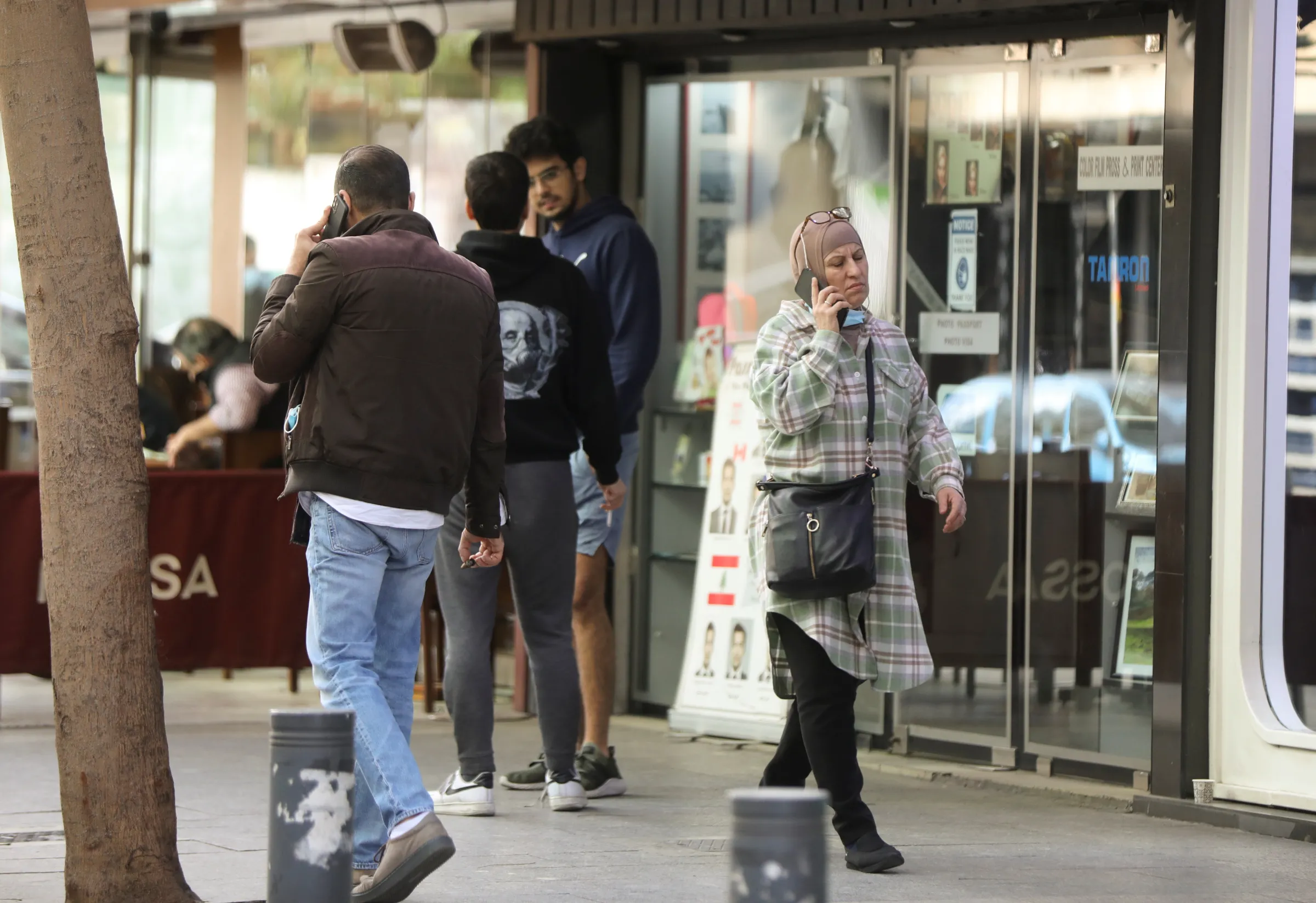 People use their mobile phones whilst walking in Beirut, Lebanon January 12, 2022. REUTERS/Mohamed Azakir