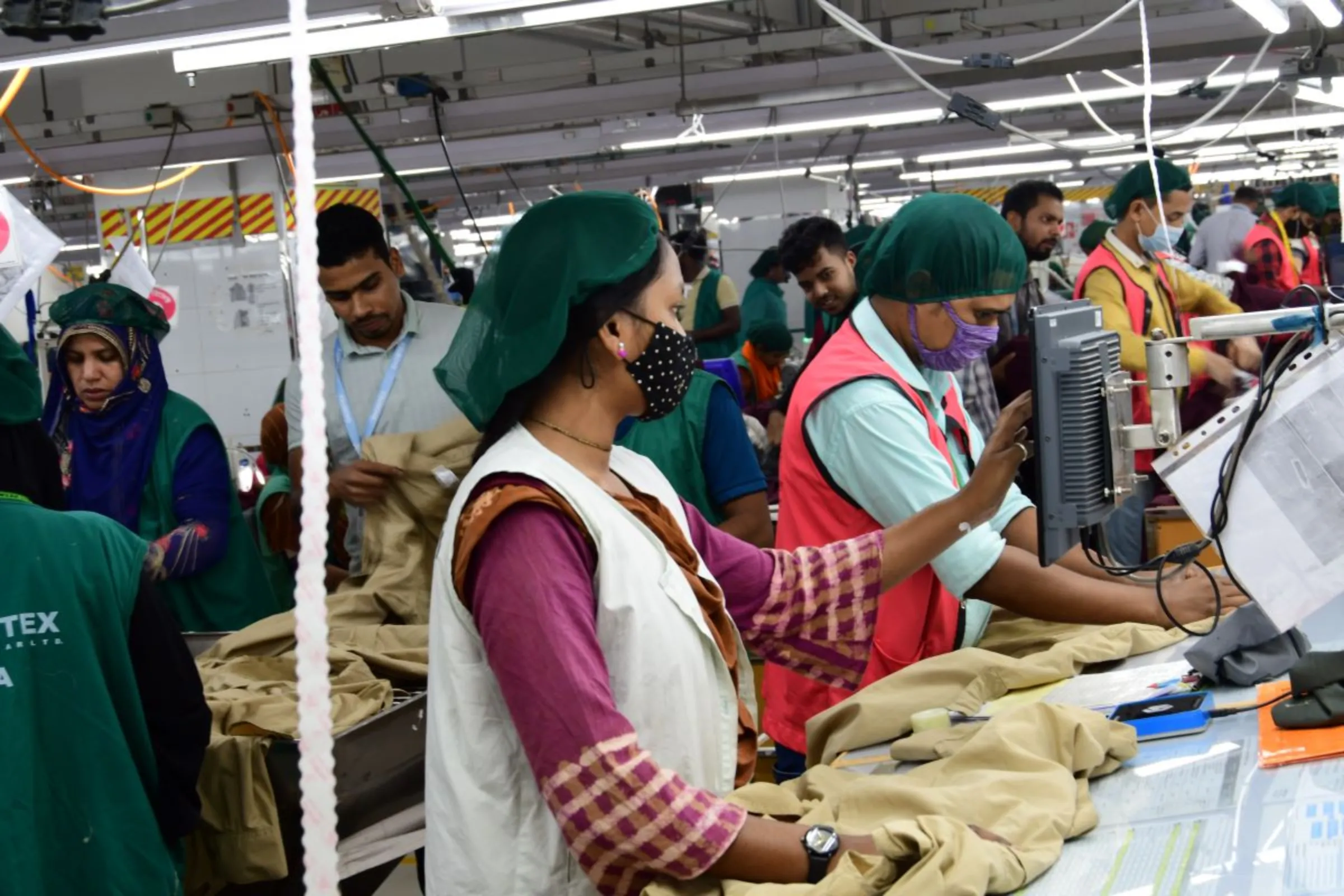 Workers finalise products at the Snowtex Outerware garment factory in Dhamrai, Bangladesh, January 30, 2023. Thomson Reuters Foundation/Mosabber Hossain