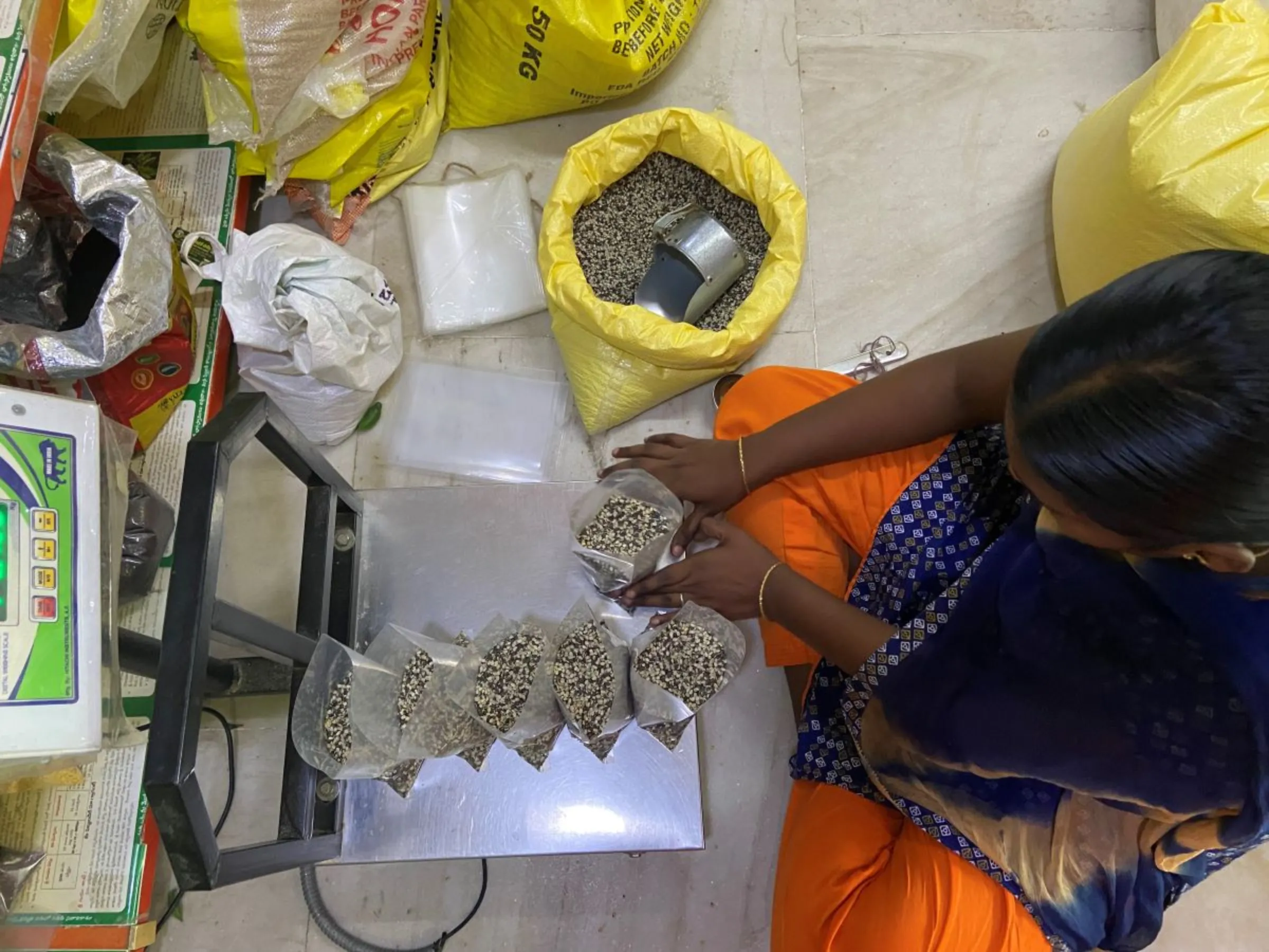 A worker packs lentils at a natural farm produce store in N.T.R District, India, September 2, 2023. Thomson Reuters Foundation/Roli Srivastava