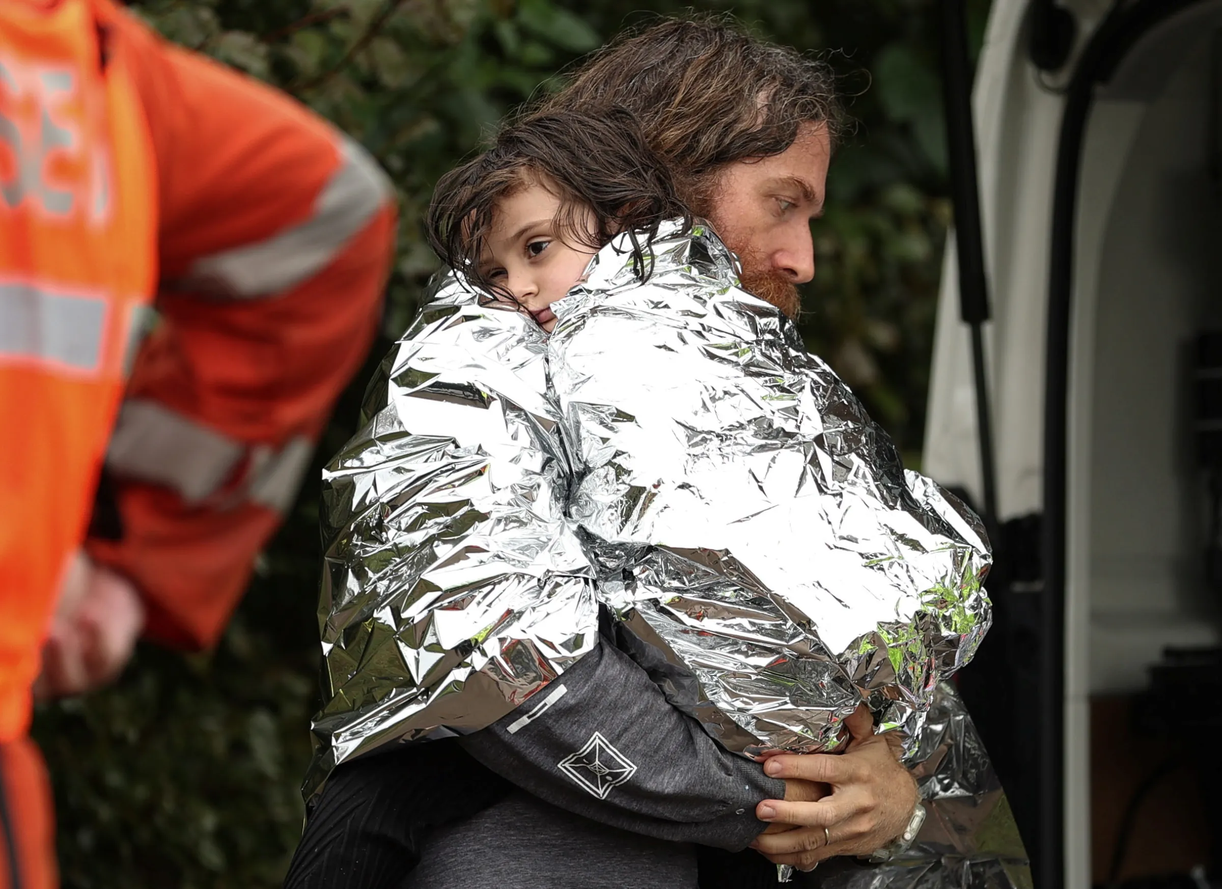 A father and child receive medical attention after the Marine Rescue boat that rescued them from rising floodwaters