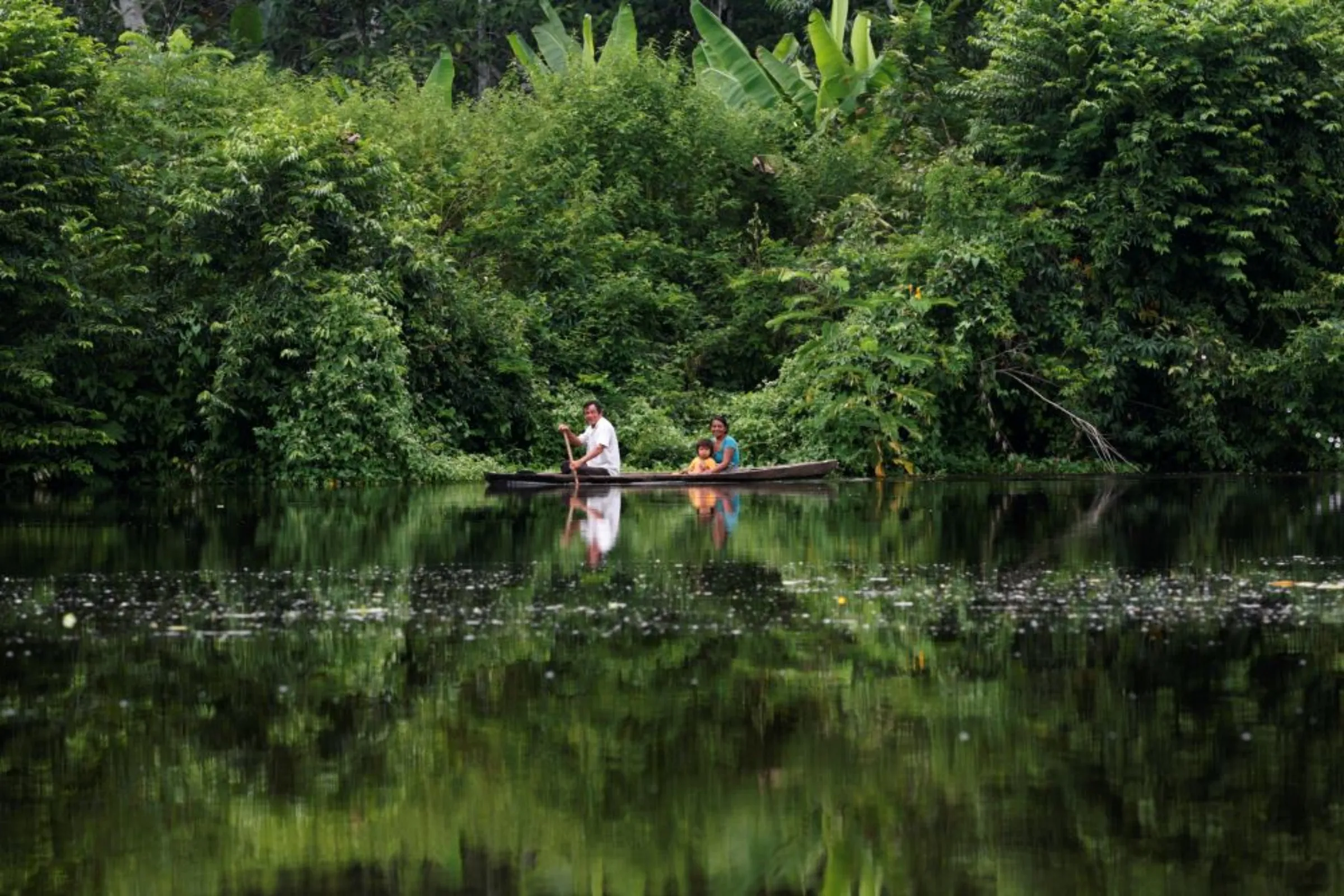 A family travels by canoe on the Maranon river in the Pacaya Samiria National Reserve in the Amazon jungle, Peru, March 28, 2008