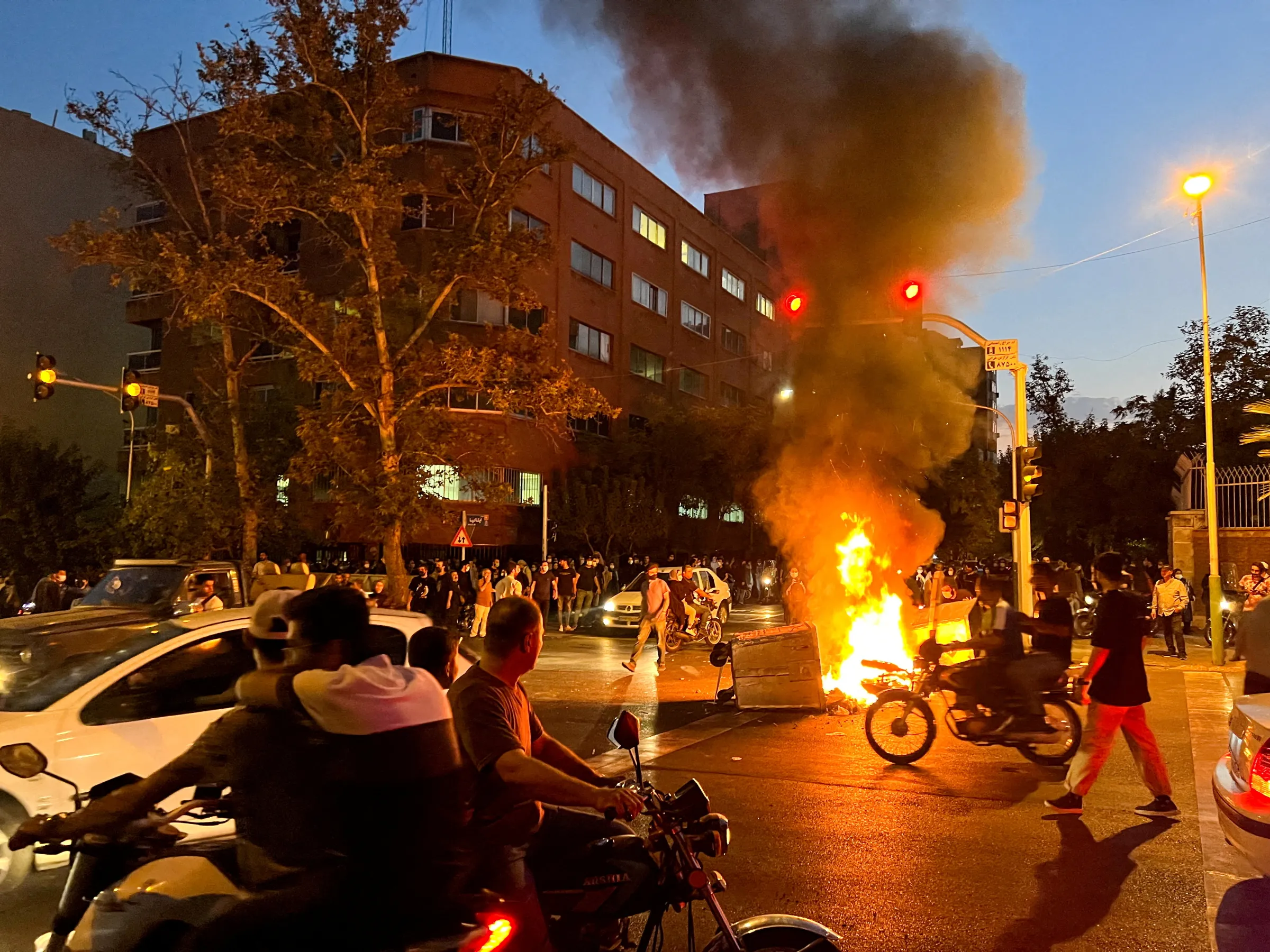 A police motorcycle burns during a protest over the death of Mahsa Amini, a woman who died after being arrested by the Islamic republic's 'morality police', in Tehran, Iran September 19, 2022. WANA (West Asia News Agency) via REUTERS