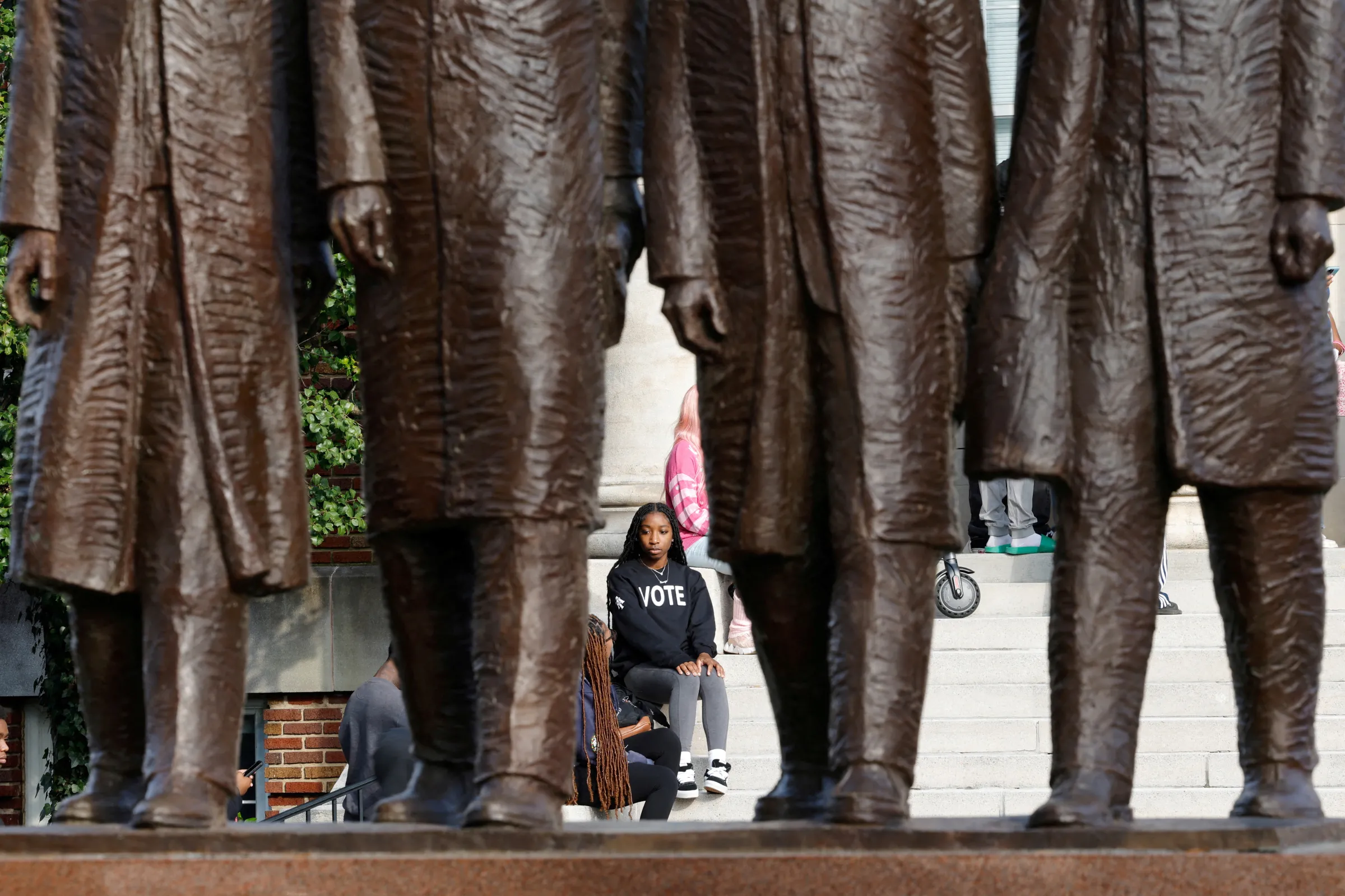 A student at North Carolina A and T State University is framed by a statue in Greensboro, North Carolina, U.S. October 28, 2024. REUTERS/Jonathan Drake