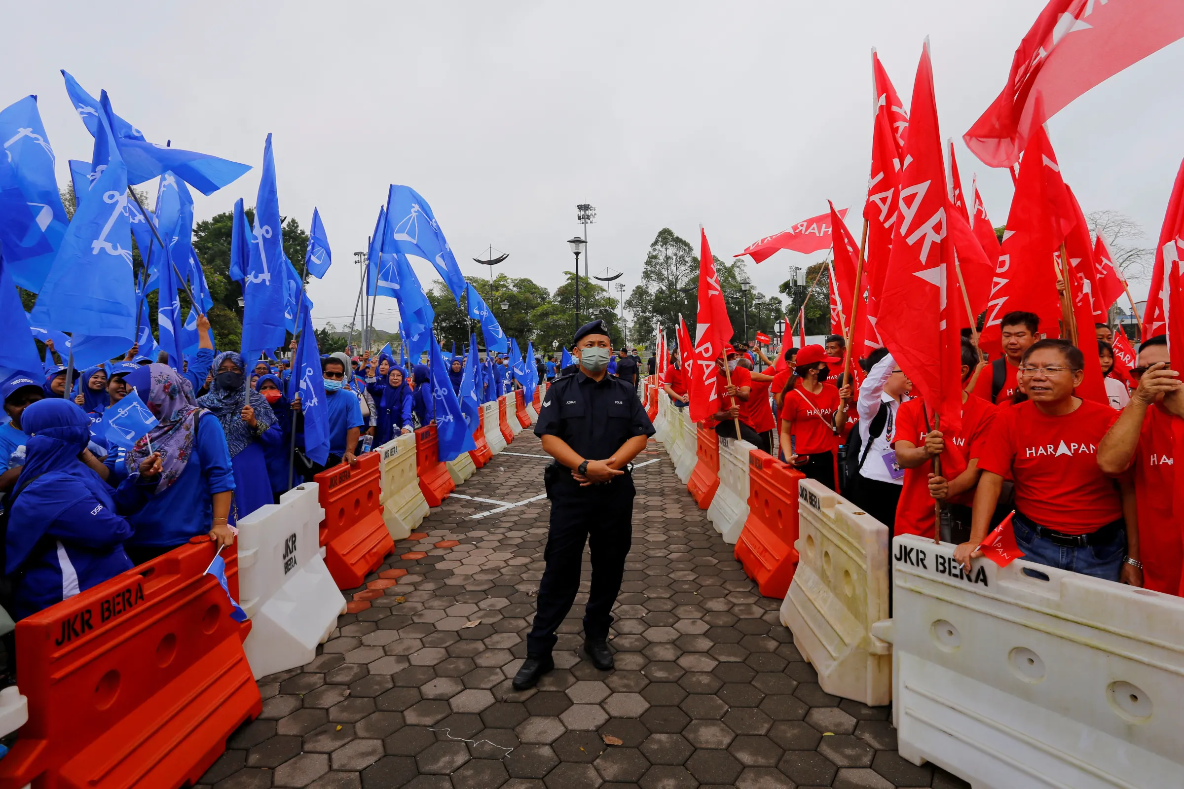 A police stands guard between supporters of The National Front coalition, Barisan Nasional, and The Alliance Of Hope, Pakatan Harapan, outside a nomination centre on nomination day in Bera, Pahang, Malaysia November 5, 2022. REUTERS/Lai Seng Sin