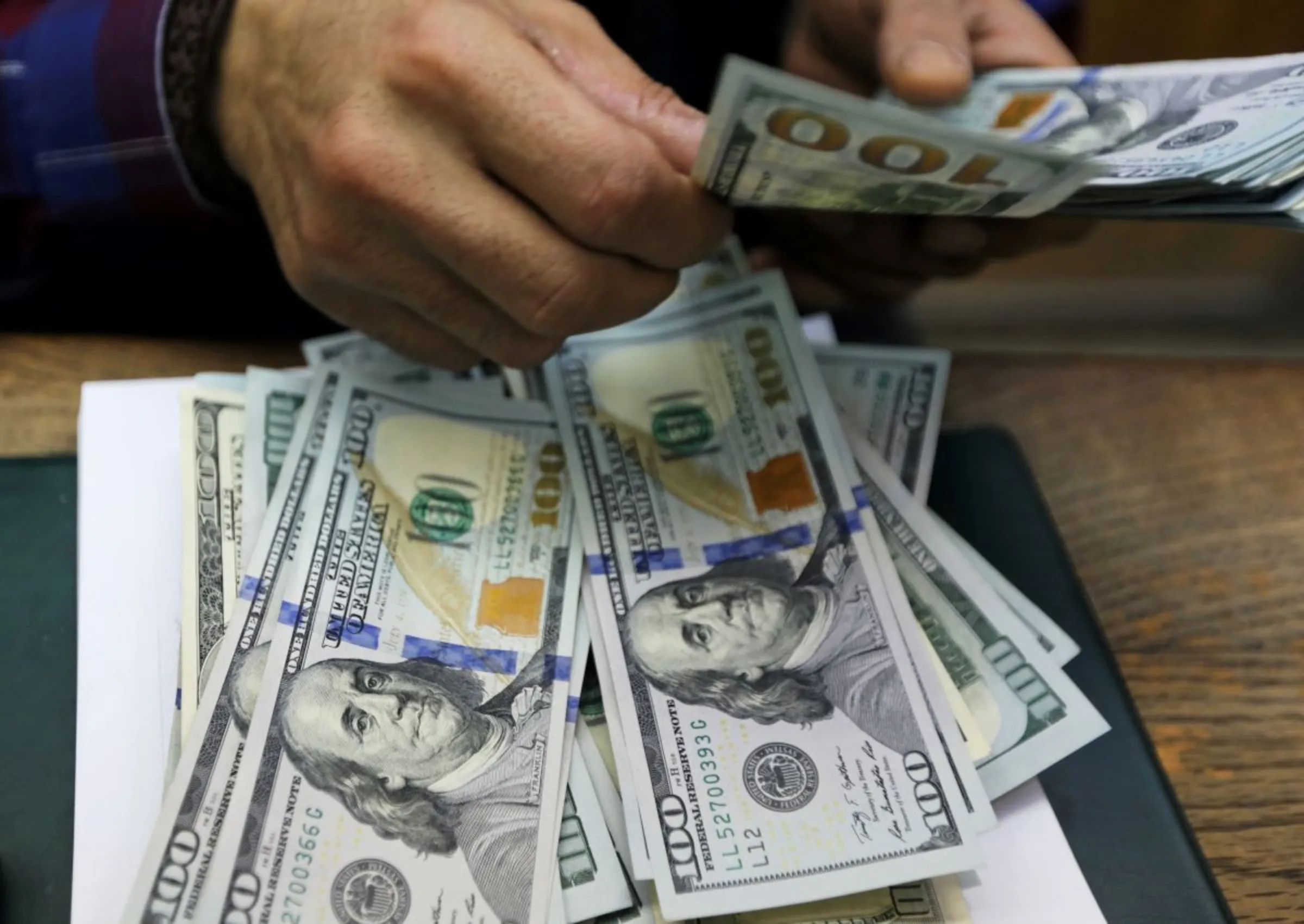 An employee counts U.S dollar bills at a money exchange office. REUTERS/Mohamed Abd El Ghany