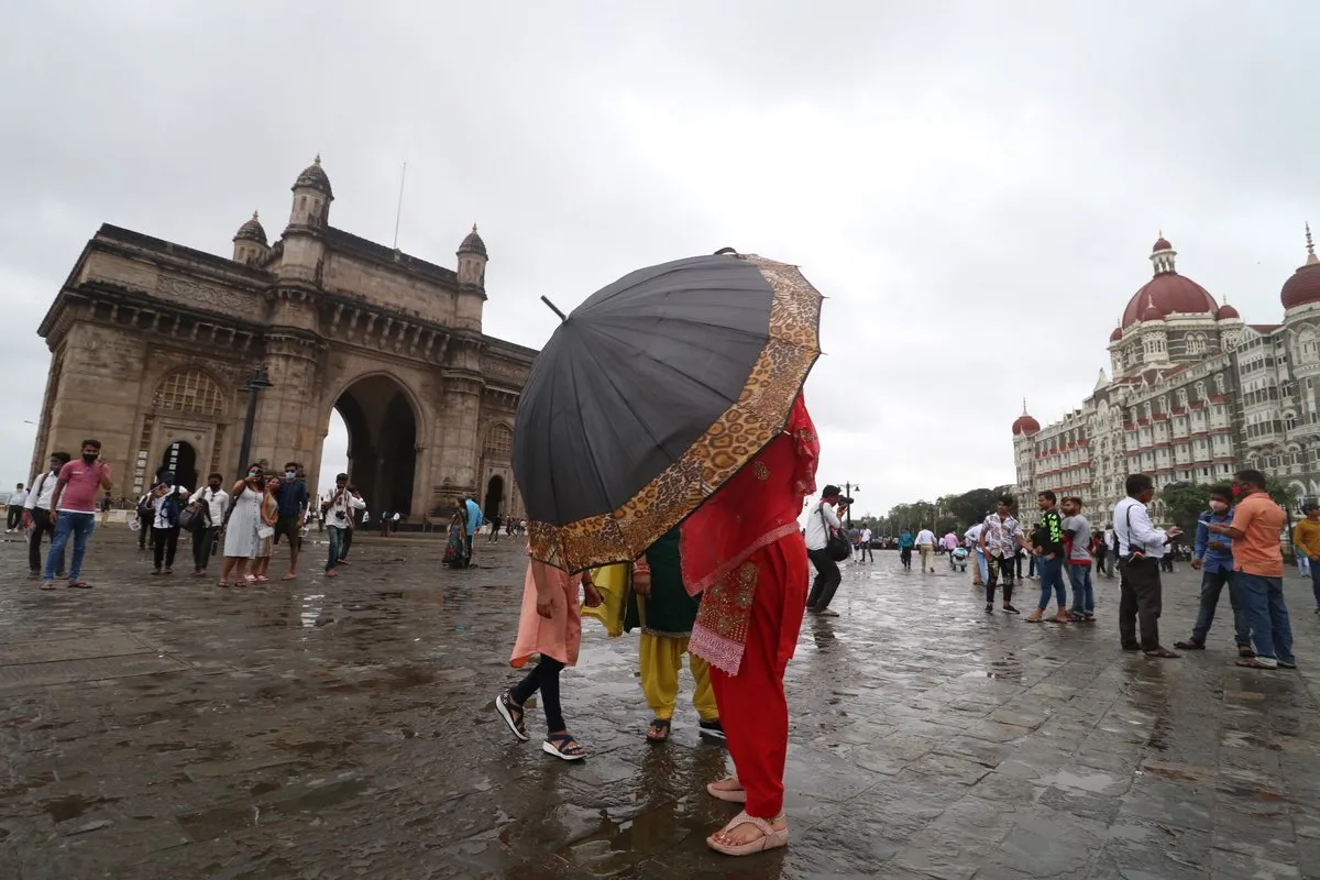 A woman shelters under an umbrella near the Gateway of India in Mumbai, India, September 13, 2021