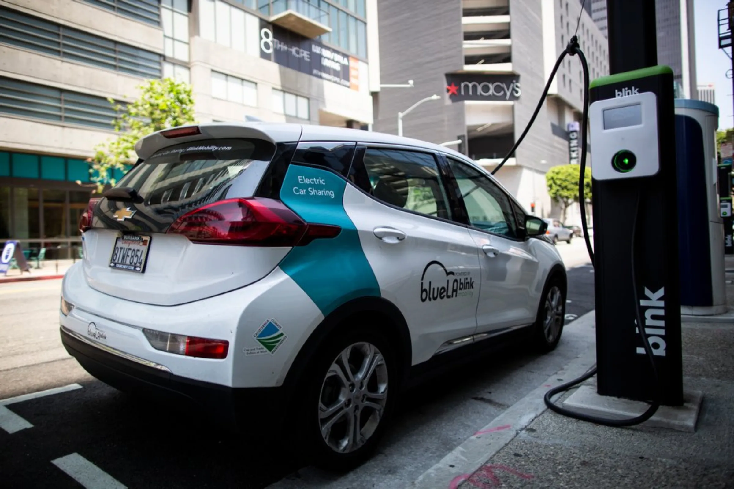 An electric car, part of a car-sharing network, charges in downtown Los Angeles, May 18, 2021