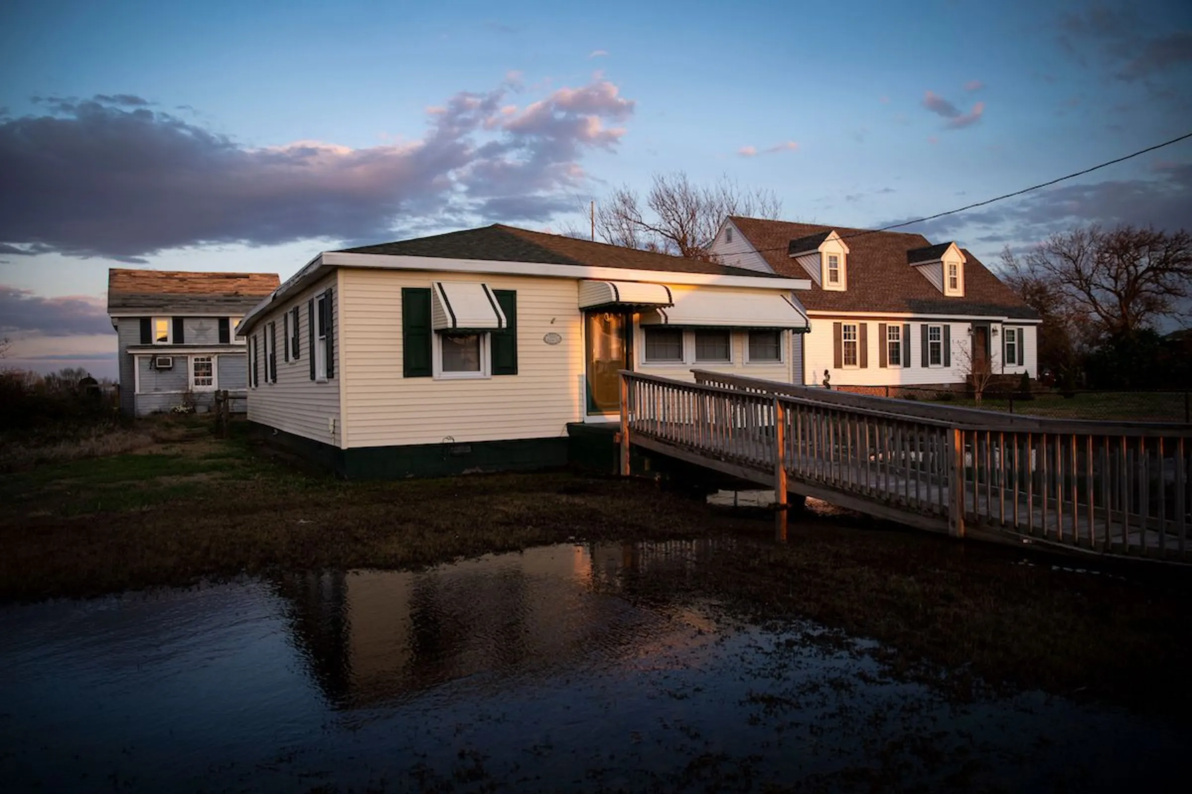 Water stands in the front yard of a house on Canton Ridge on the eastern side of Tangier Island, Virginia, U.S., March 27, 2022. Thomson Reuters Foundation/Al Drago