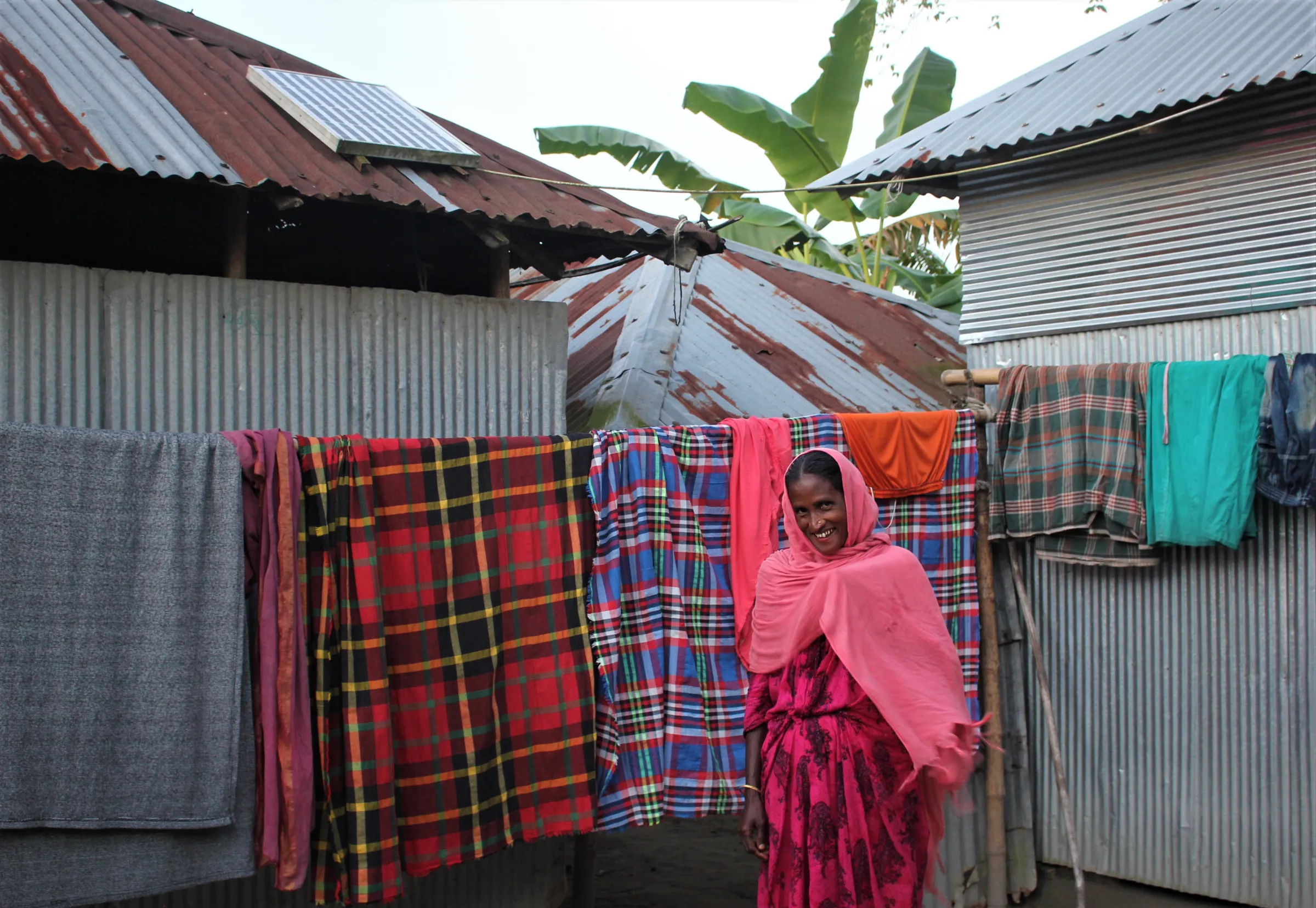 Zahura Khatun (40), from a remote northern village of Bangladesh, poses for a photo before her rooftop solar plant that helps her do household chores and educate her children, Lalmonirhat, Bangladesh, October 10, 2022