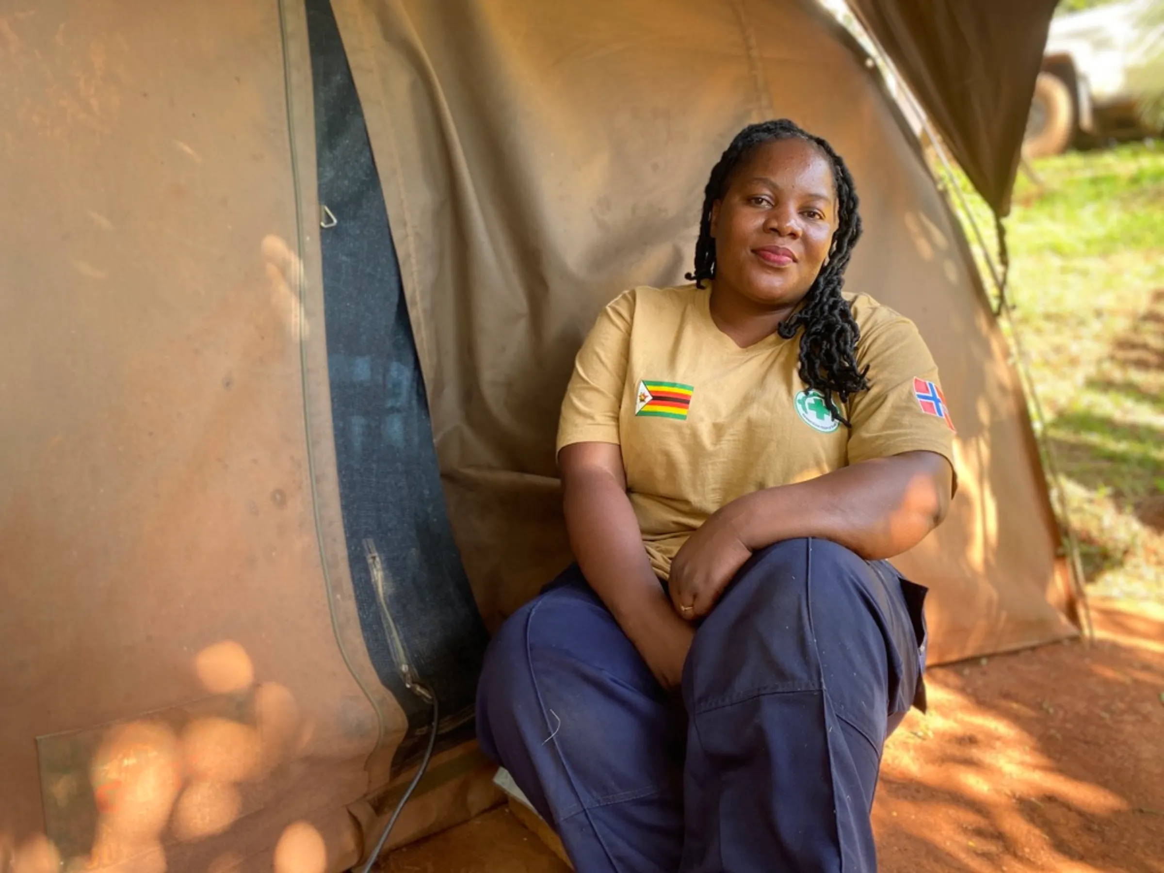 Memory Mutepfa, a female deminer, sits outside her tent in the camp in Chipinge, Zimbabwe, December 16, 2022. Thomson Reuters Foundation/Farai Shawn Matiashe