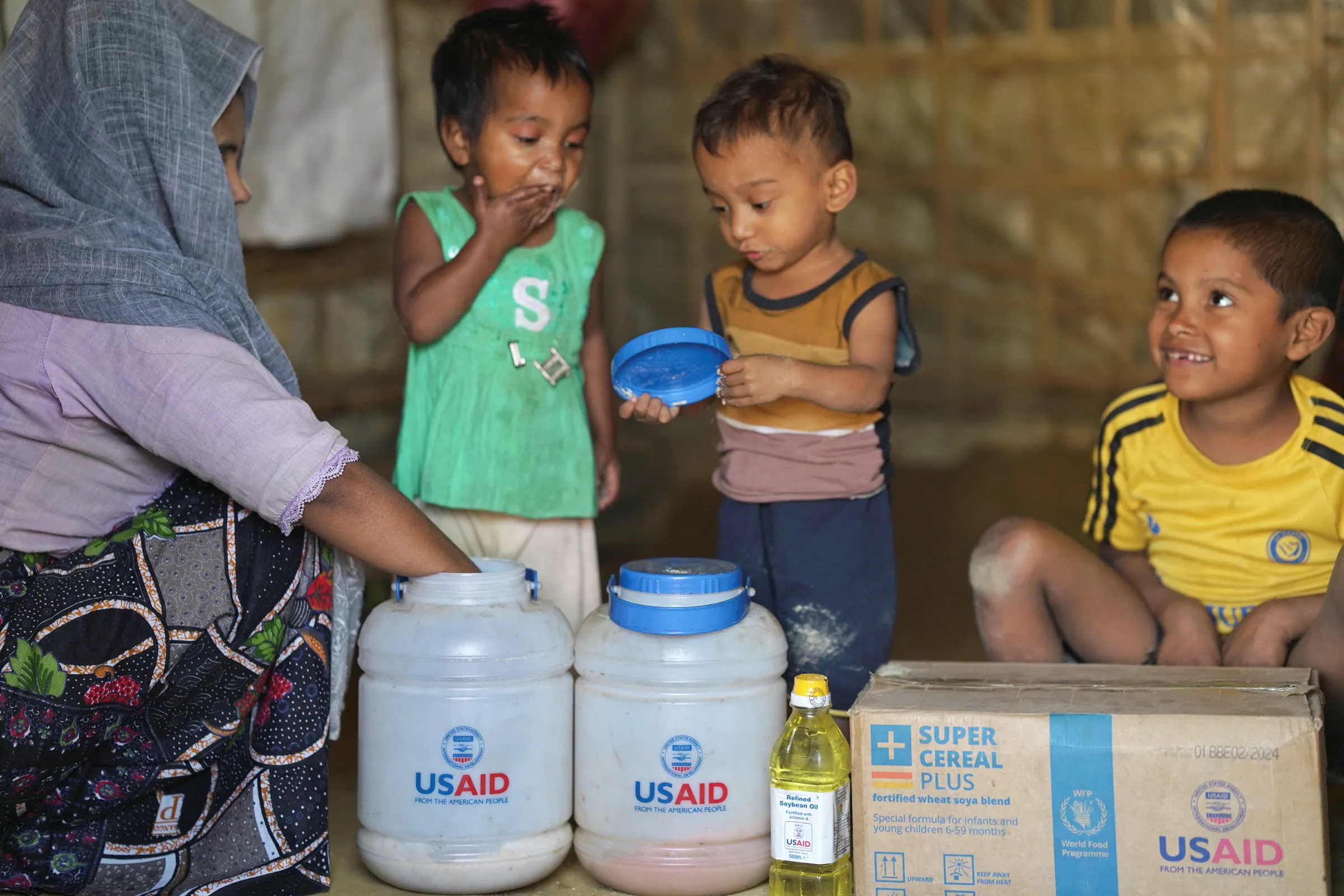 Rohingya children eat from jars with the USAID logo on them, at a refugee camp in Cox's Bazar, Bangladesh, February 11, 2025. REUTERS/Ro Yassin Abdumonab