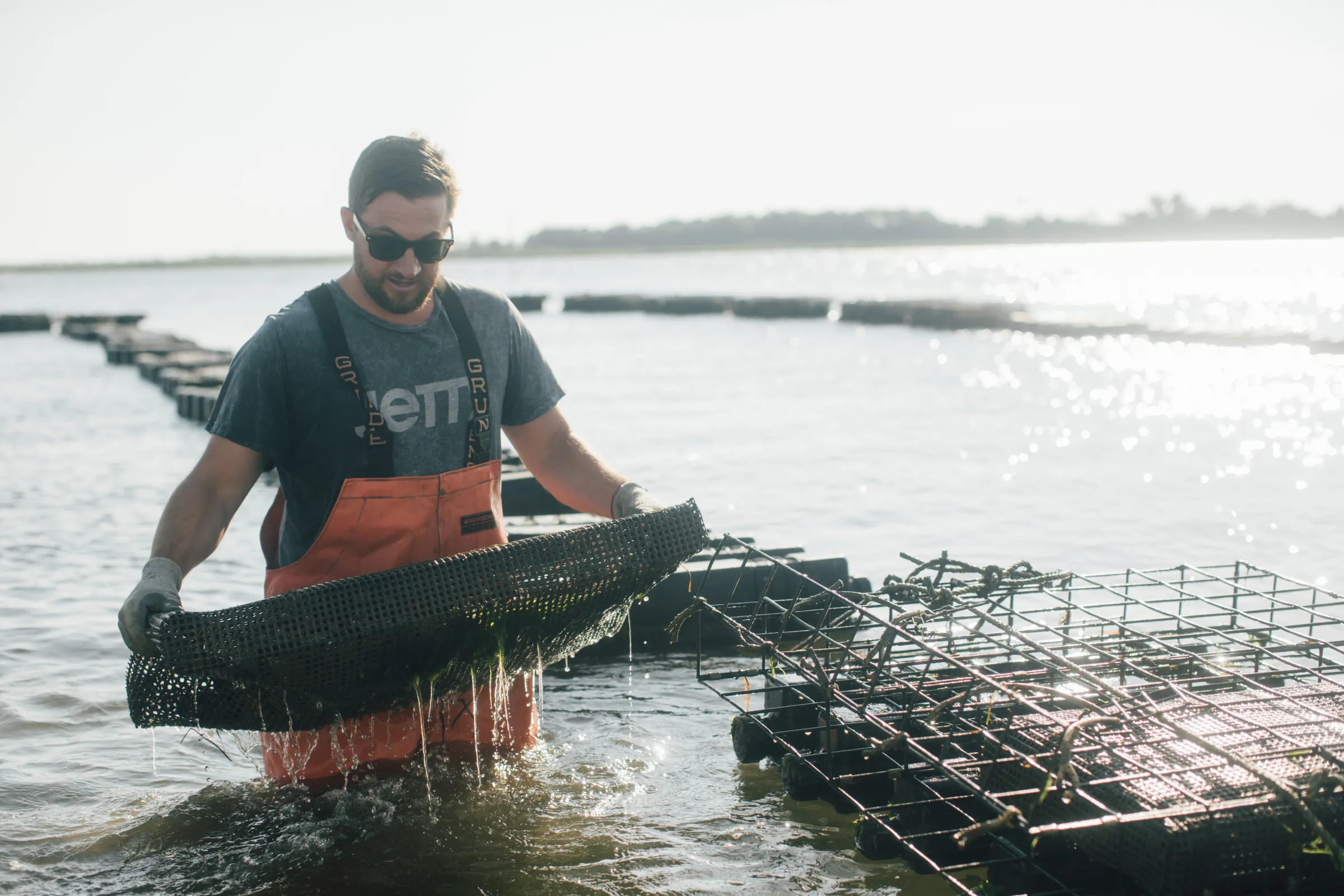 A worker in the waters of an oyster farm along the New Jersey coast. Kyle Gronostajski/Jetty Rock Foundation/ Handout via Thomson Reuters Foundation