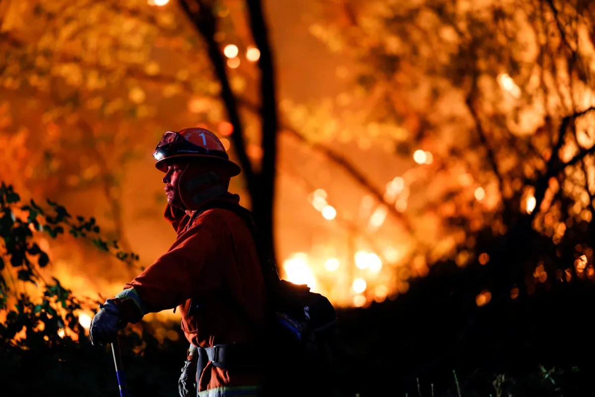 A firefighter monitors flames which were threatening homes by the River Fire, a wildfire near the town of Grass Valley, California, U.S., August 4, 2021. REUTERS/Fred Greaves