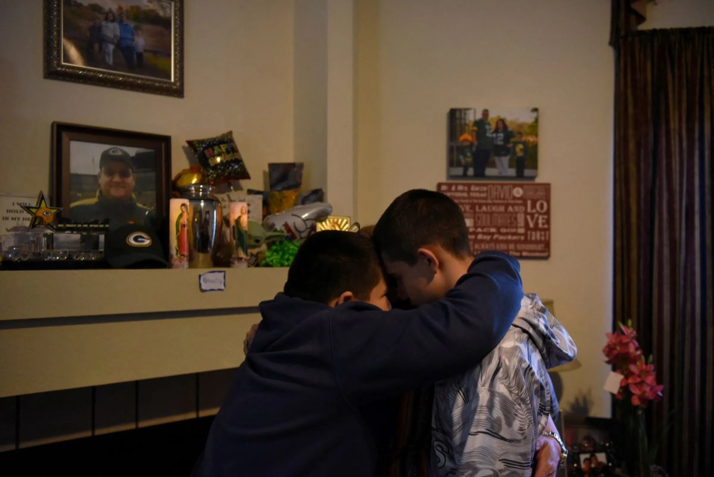 Children pray with their mother next to their father’s urn, which they call 'the vessel,' in Converse, Texas, U.S March 30, 2022. REUTERS/Callaghan O'Hare