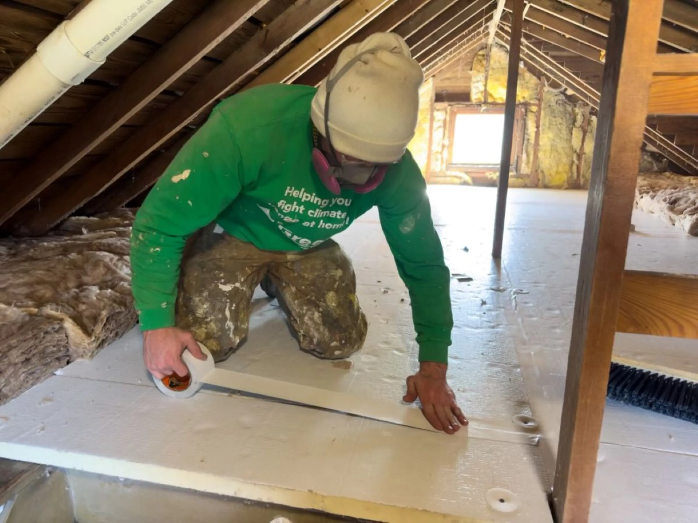 Worker Harrison P. installs rigid insulation in a home in outside Milwaukee on March 15, 2024. Jack Phillips/Green Homeowners United/Handout via Thomson Reuters Foundation