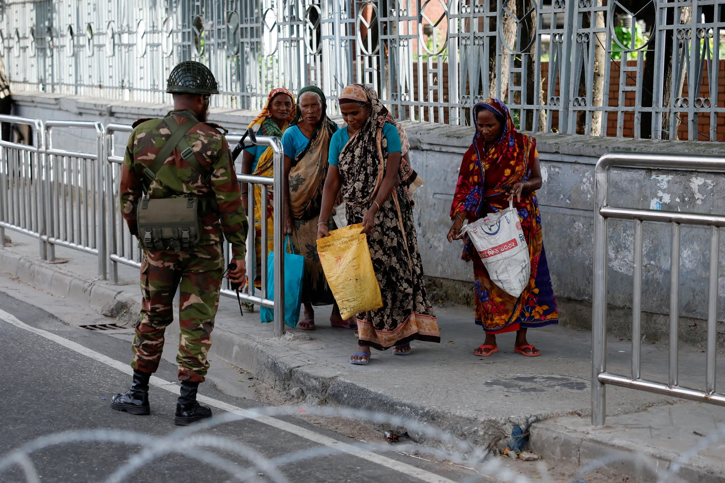 A member of the Bangladesh Army checks bags of women during a curfew imposed in response to student-led protests against government job quotas, in Dhaka, Bangladesh, July 20, 2024. REUTERS/Mohammad Ponir Hossain