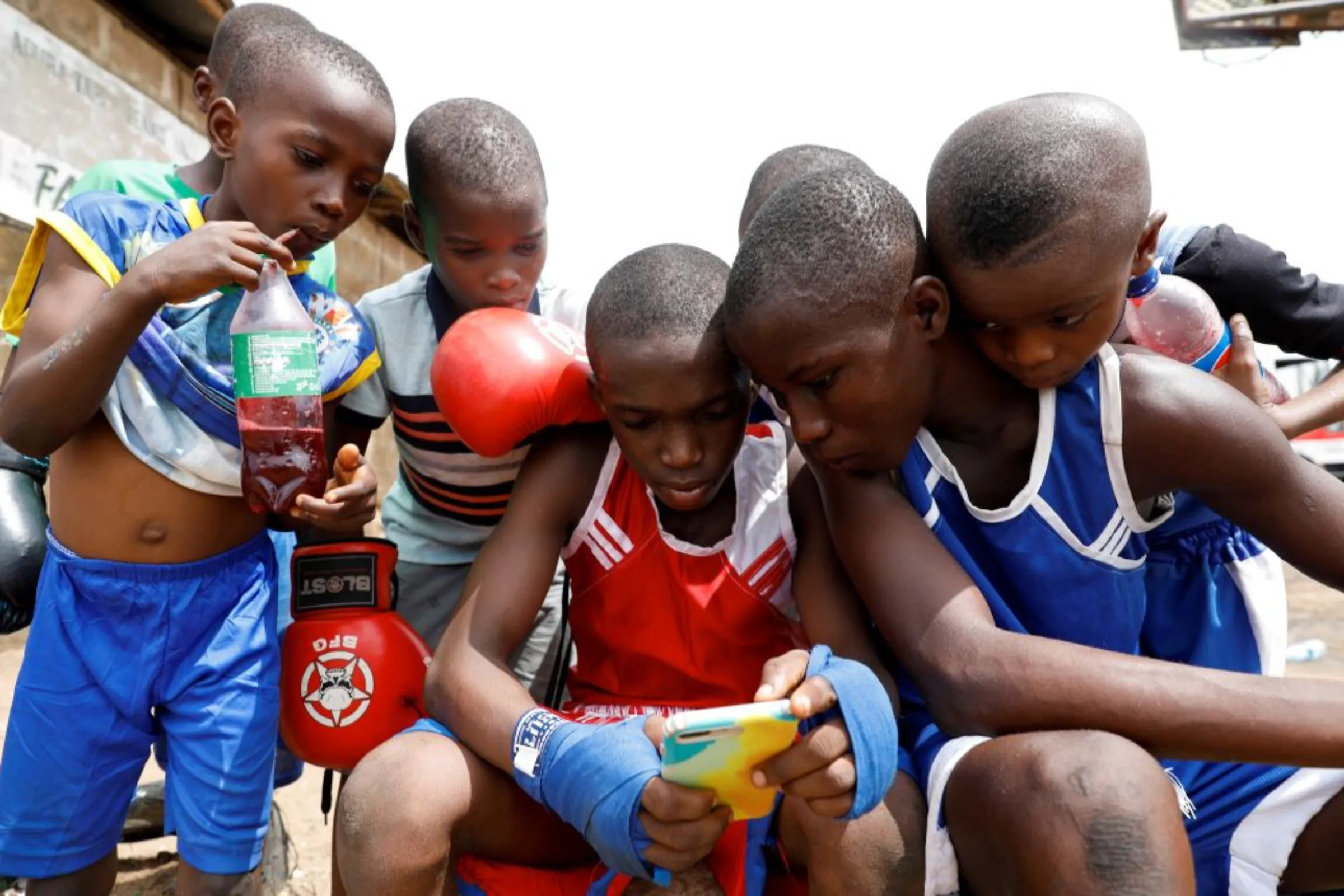 Kid boxers watch a video on a mobile phone together after a training session at the boxing gym in Adura playground, in Lagos, Nigeria June 5, 2021
