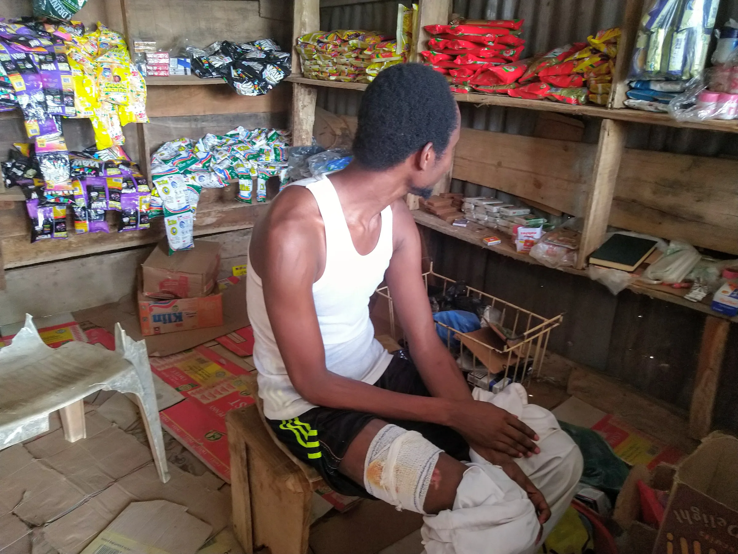 A man turns his face from the camers as he sits inside a tent