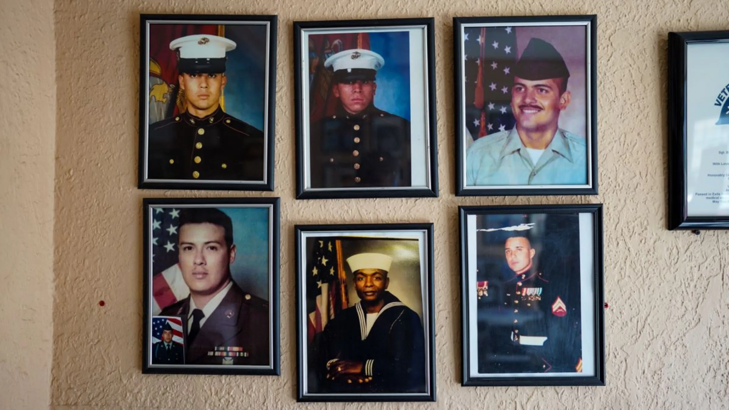 Photos of deported veterans at the offices of Robert Vivar, in Tijuana, Mexico, February, 22 2023. Thomson Reuters Foundation/Manuel Ocano.