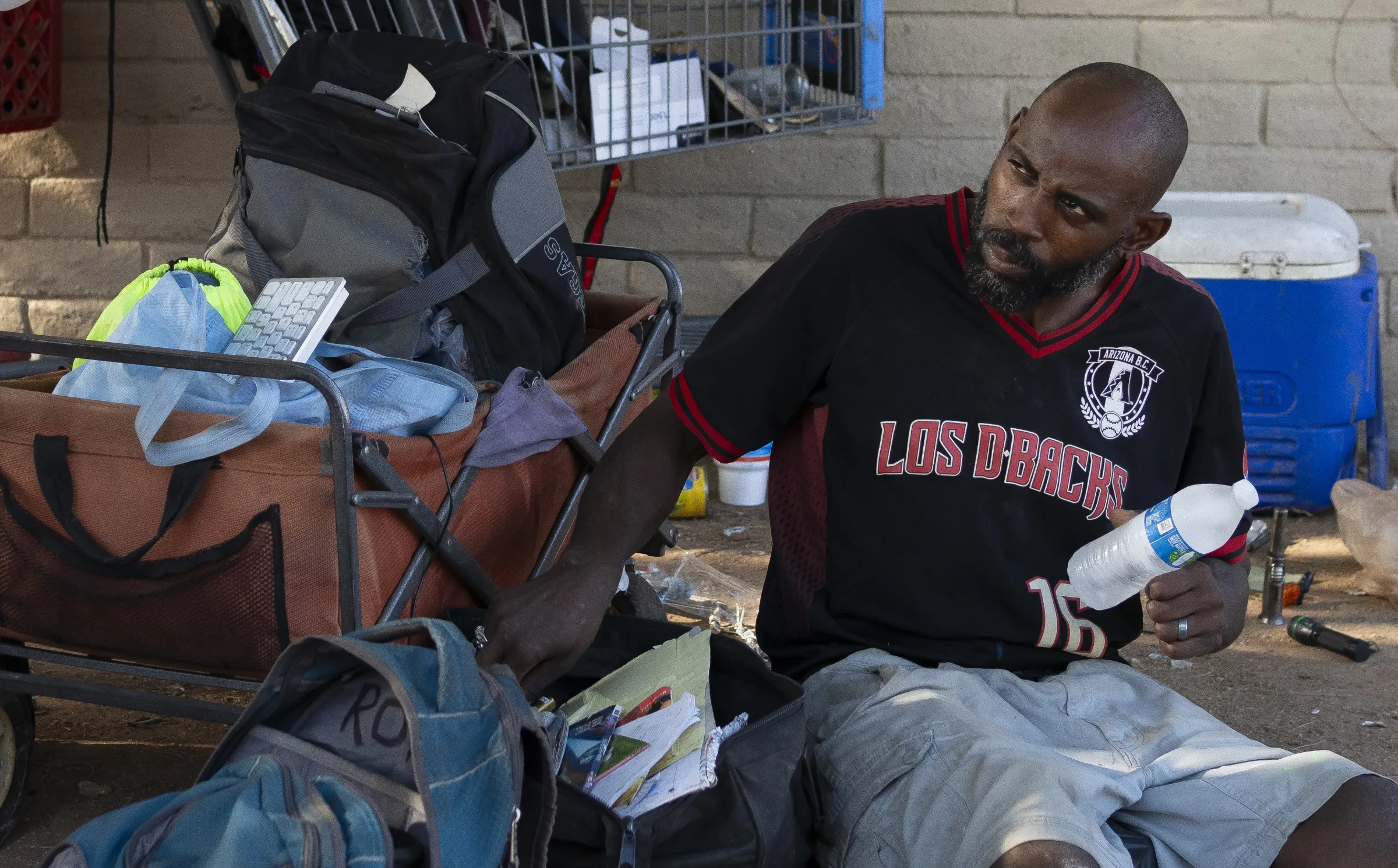 Tyrone James listens to the street medic team offering free medical care to street residents at their nearby van in Phoenix, Arizona. July 15, 2024. Thomson Reuters Foundation/Rebecca Noble