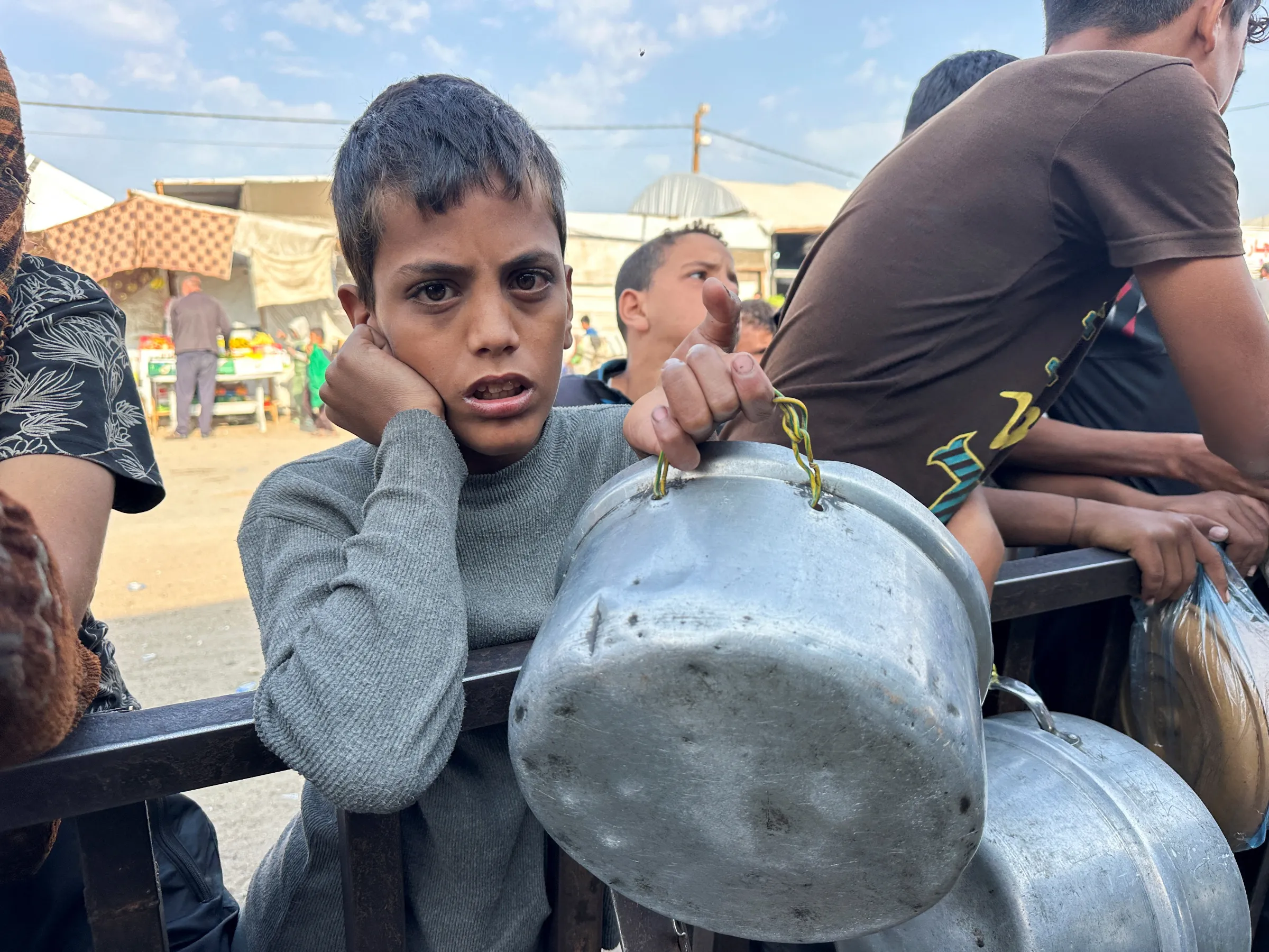 A Palestinian boy waits to receive food from a charity kitchen amid a ceasefire between Israel and Hamas, in Khan Younis in the southern Gaza Strip, November 5, 2025. REUTERS/Haseeb Alwazeer