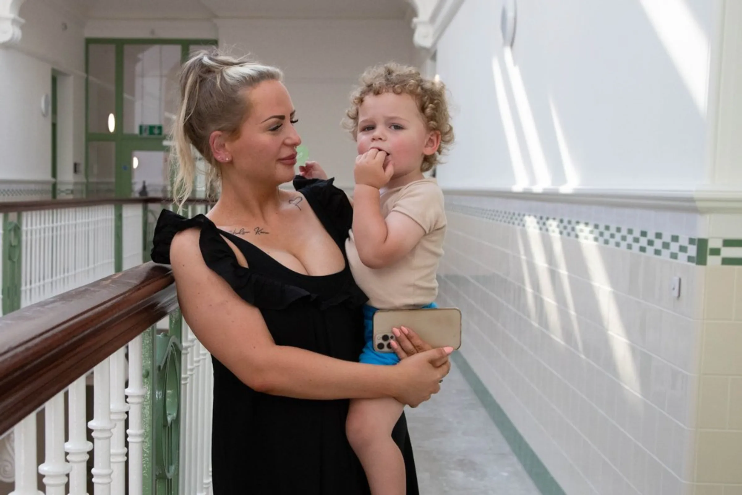 Glasgow resident Hollie Osborne holds her two-year-old son outside her home in Glasgow, United Kingdom, July 20, 2021. Osborne found her son was repeatedly falling ill after she was unable to heat her home due to high energy bills