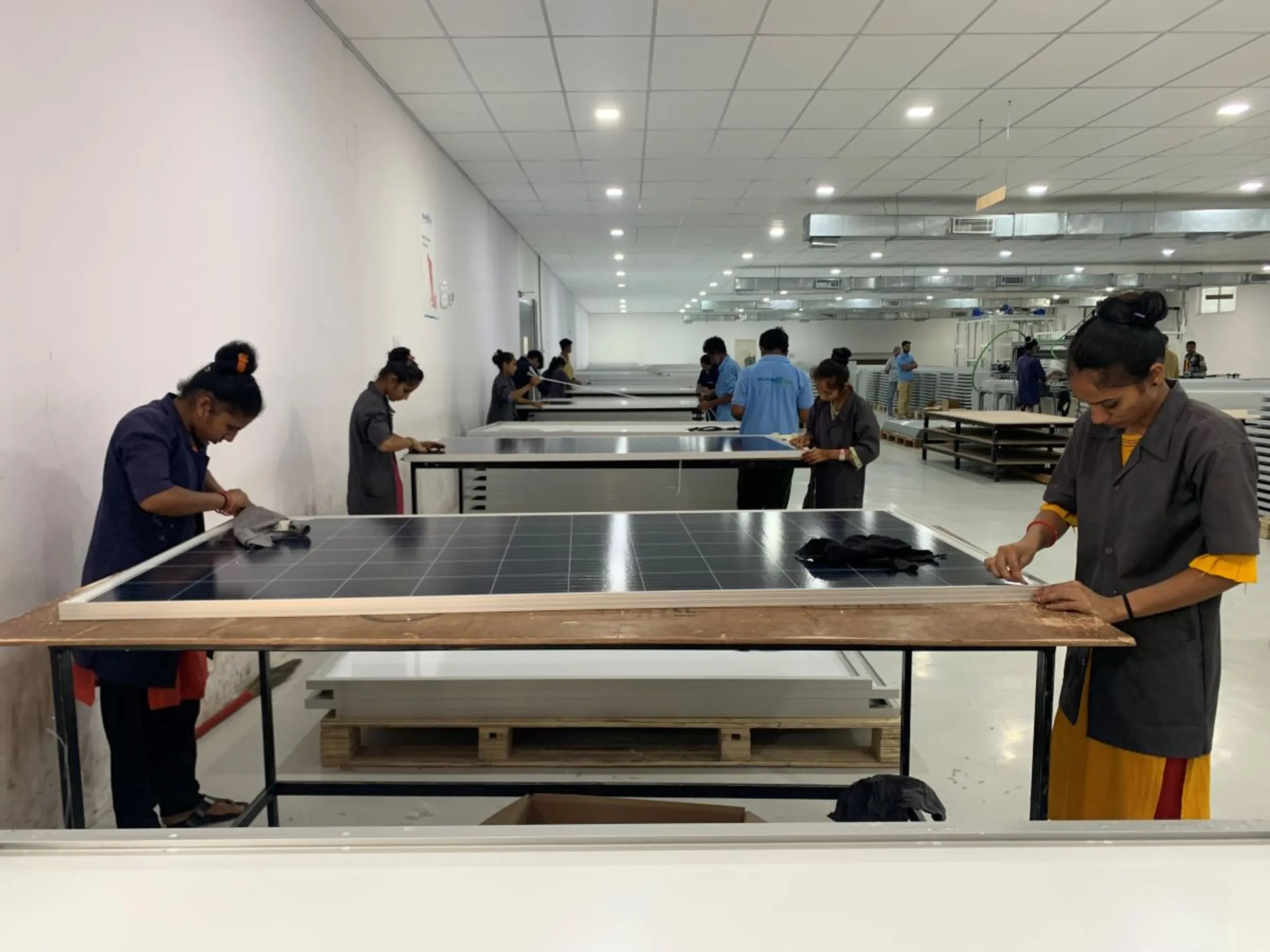 Women workers giving finishing touches to solar panels manufactured at Sunbond Energy Pvt Ltd in Mitana in Gujarat, India, May 29, 2023. Thomson Reuters Foundation/Anuradha Nagaraj