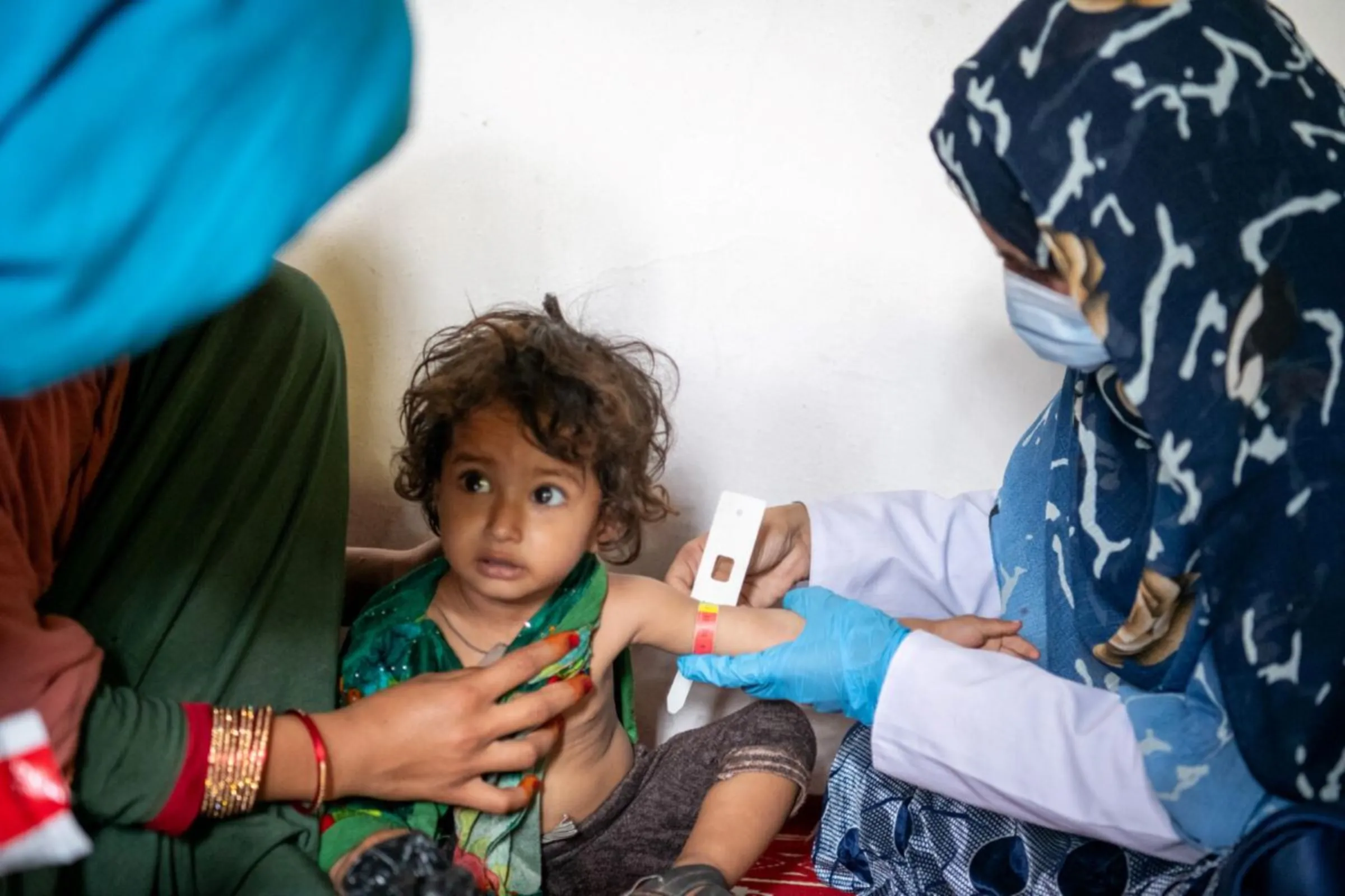 A nutrition nurse checks a child's arm circumference for signs of malnutrition at a UNICEF-supported mobile health unit in Nari District, Kunar Province, Afghanistan on 25 June 2023