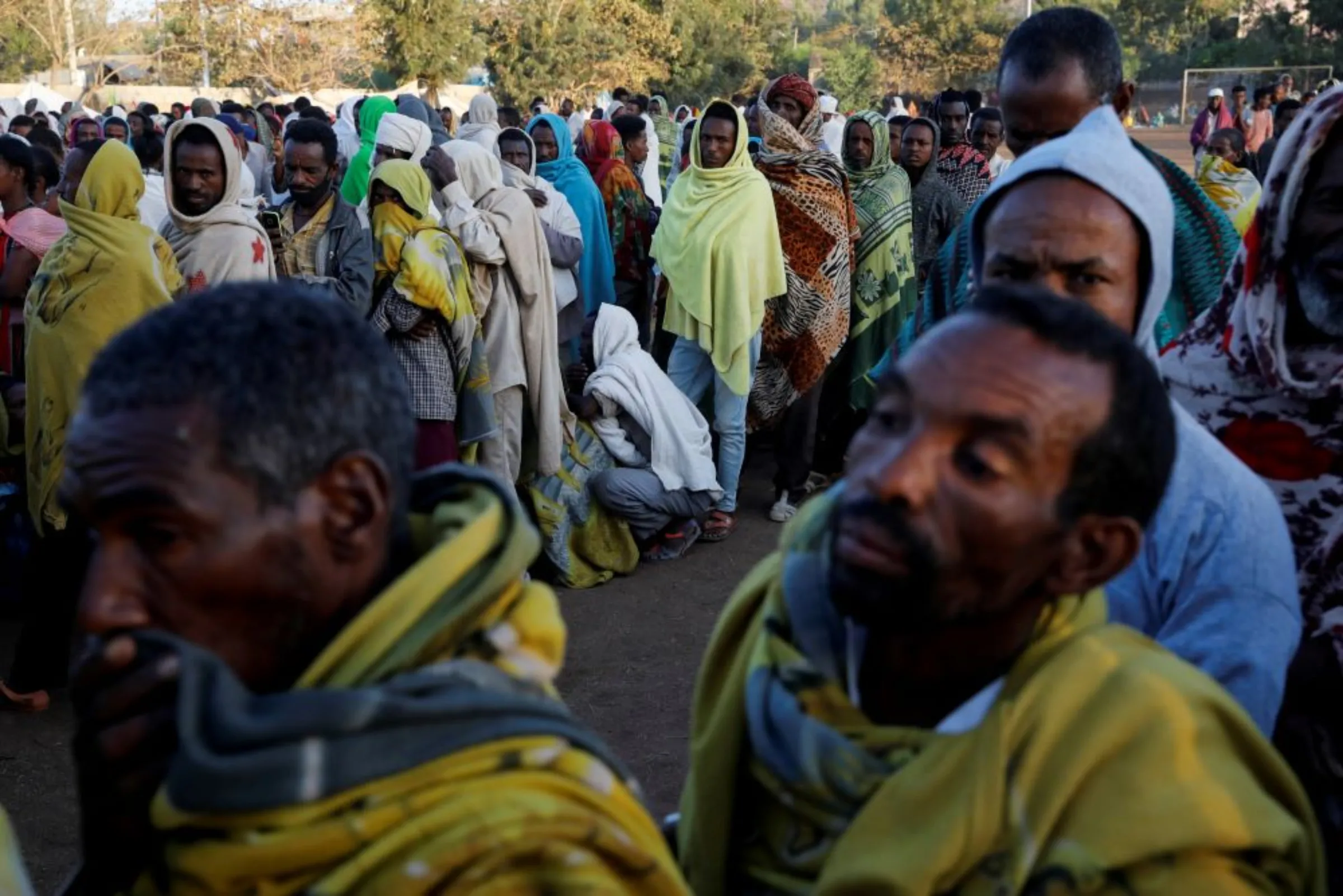 Displaced people queue for food at the Tsehaye primary school, which was turned into a temporary shelter for people displaced by conflict, in the town of Shire, Tigray region, Ethiopia, March 15, 2021