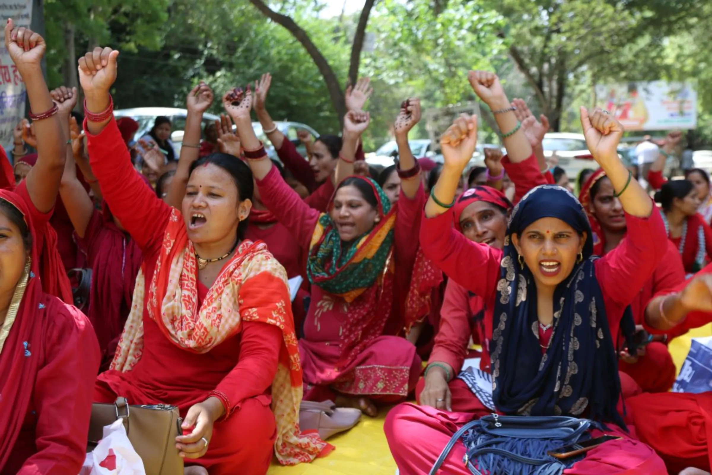 Community health workers punch the air with their fists during a protest in Gurugram, India, September 19, 2023