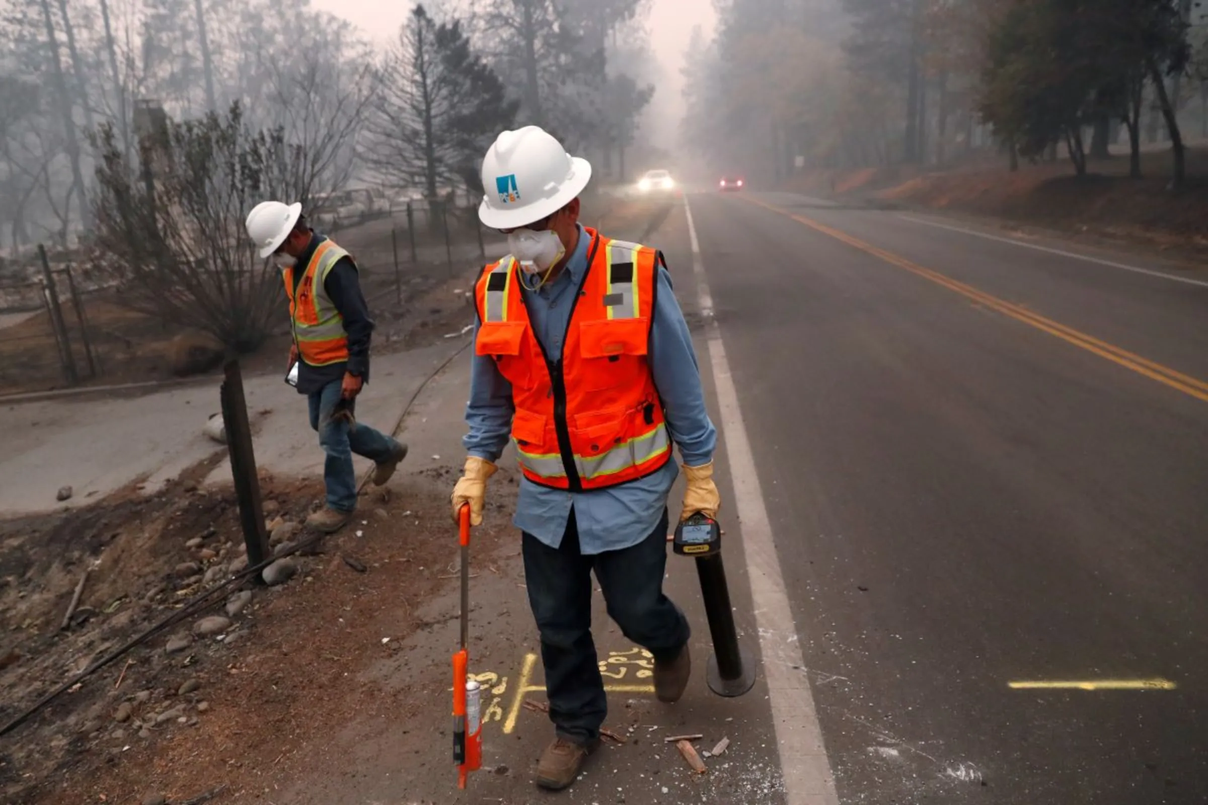 Employees of Pacific Gas & Electric (PG&E) mark gas lines in the aftermath of the Camp Fire in Paradise, California, U.S., November 14, 2018