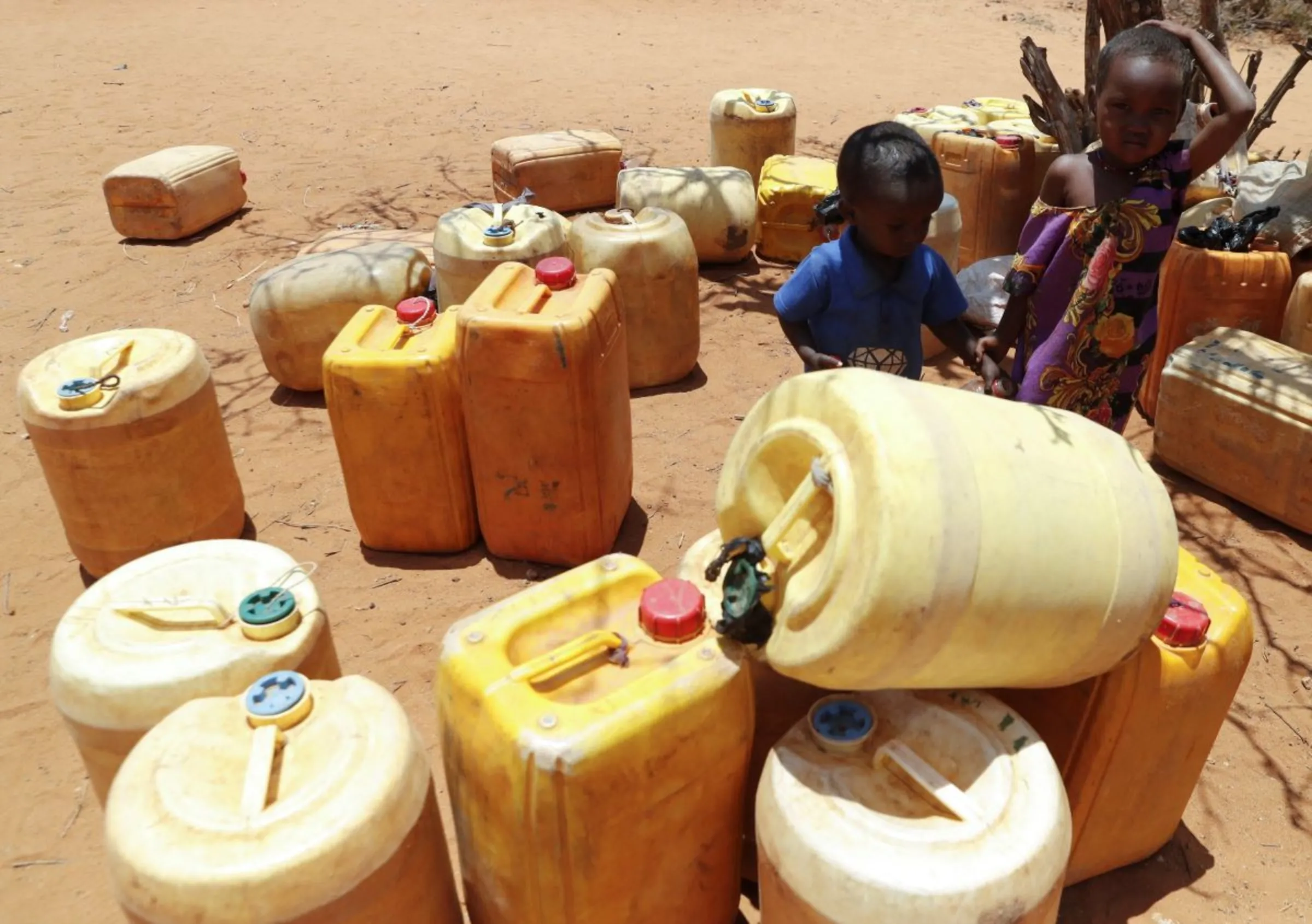 Children stand by their family jerrycans as they wait for their turn to collect water at a borehole following a prolonged drought near the Kenya-Ethiopia border in Kubdishan, in Mandera region, Kenya September 1, 2022. REUTERS/Thomas Mukoya