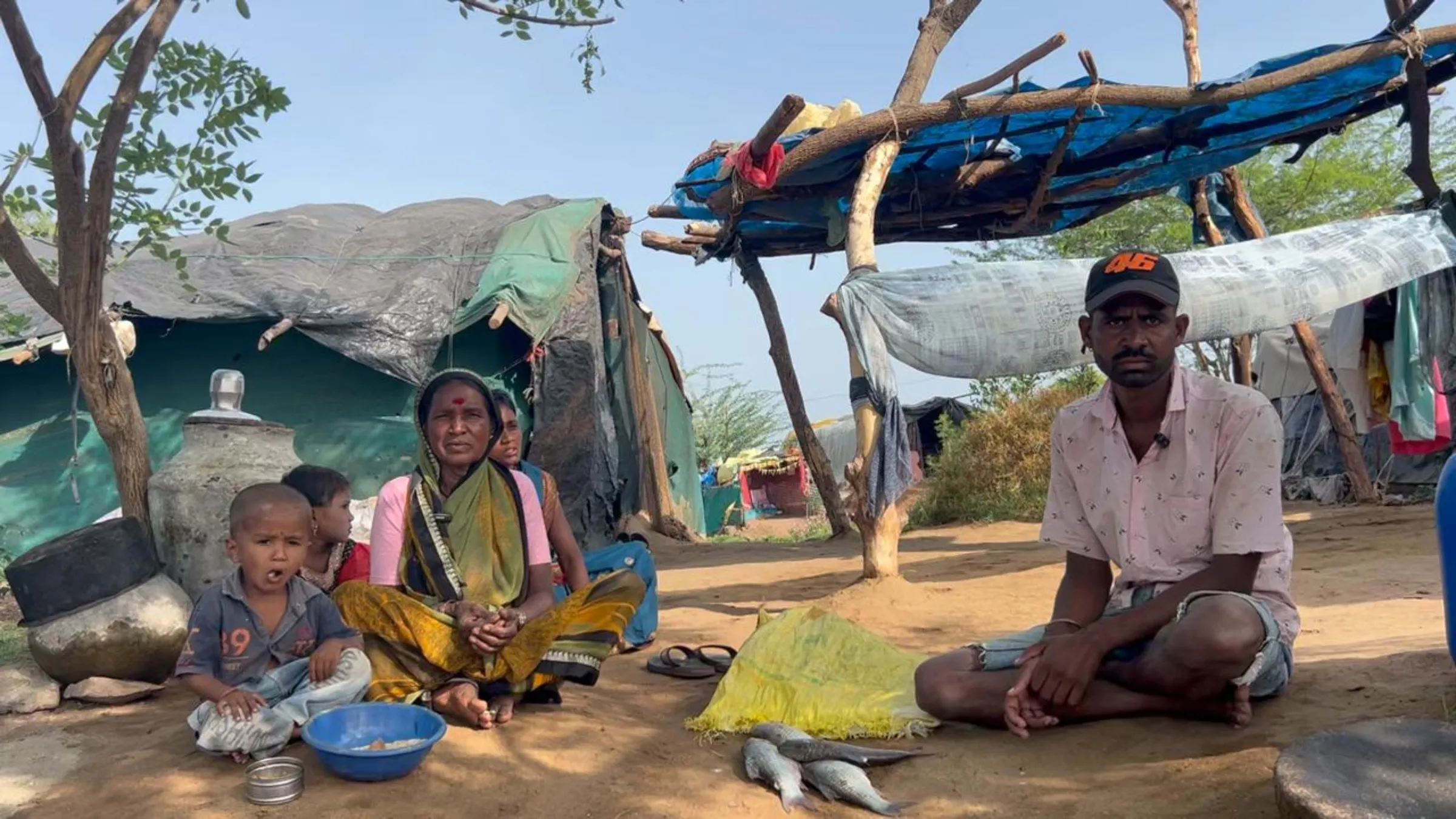 Fisherman Nitin Birute (R) sits with his family near Jayakwadi Dam, where they are protesting a floating solar plant, near Paithan in Maharashtra state, India, in June 2024. Thomson Reuters Foundation/Yash Sadhak Shrivastava