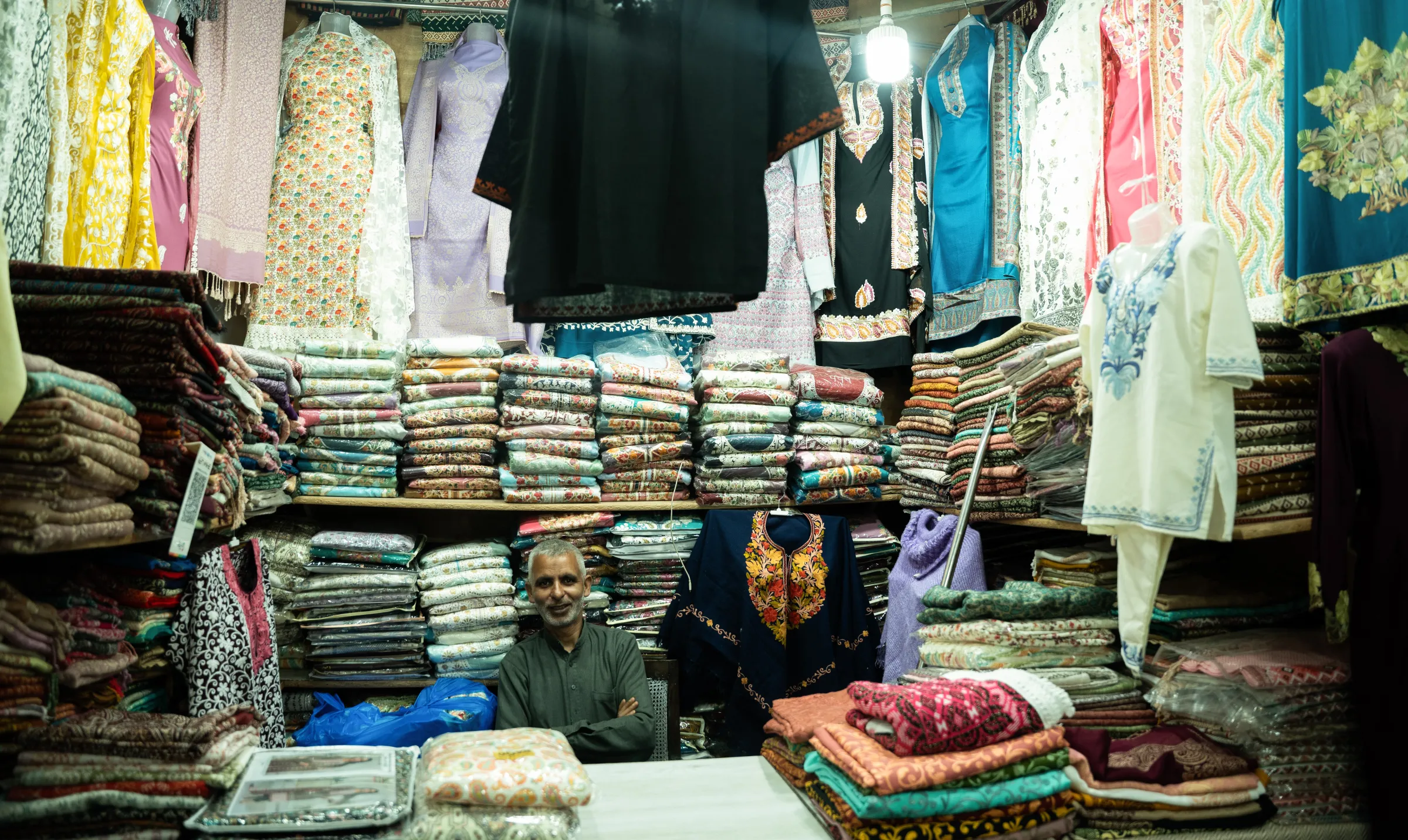 A Kashmiri shopkeeper selling traditional Kashmiri clothes waits for tourists to visit his shop. April 24, 2025. Mehran Firdous/Thomson Reuters Foundation