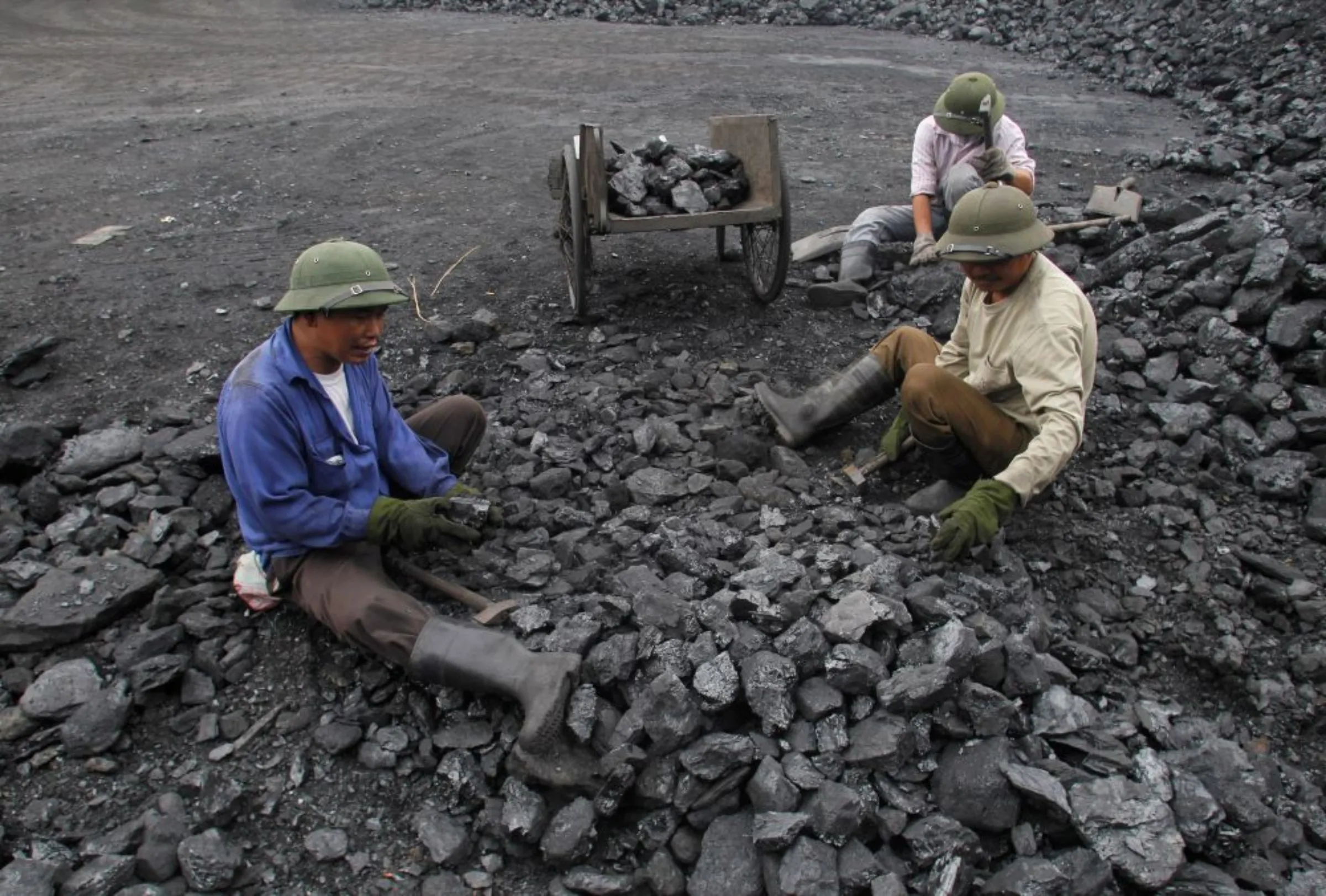 Workers pick out gravel from coal at a coal port in Hanoi February 23, 2012