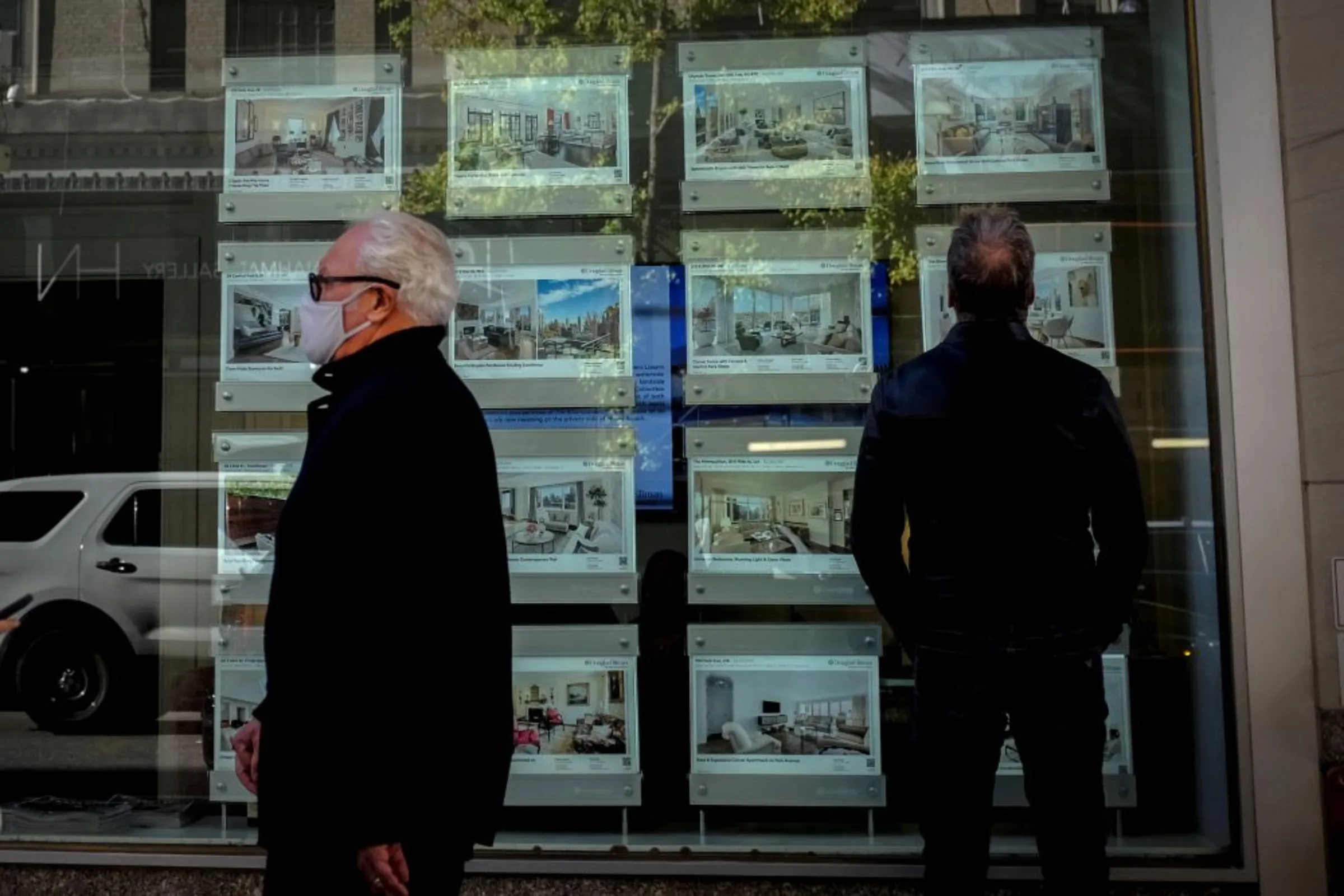 A man looks at advertisements for luxury apartments and homes in the window of Real Estate sales business in Manhattan's upper east side neighborhood in New York City, New York, U.S. October 19, 2021
