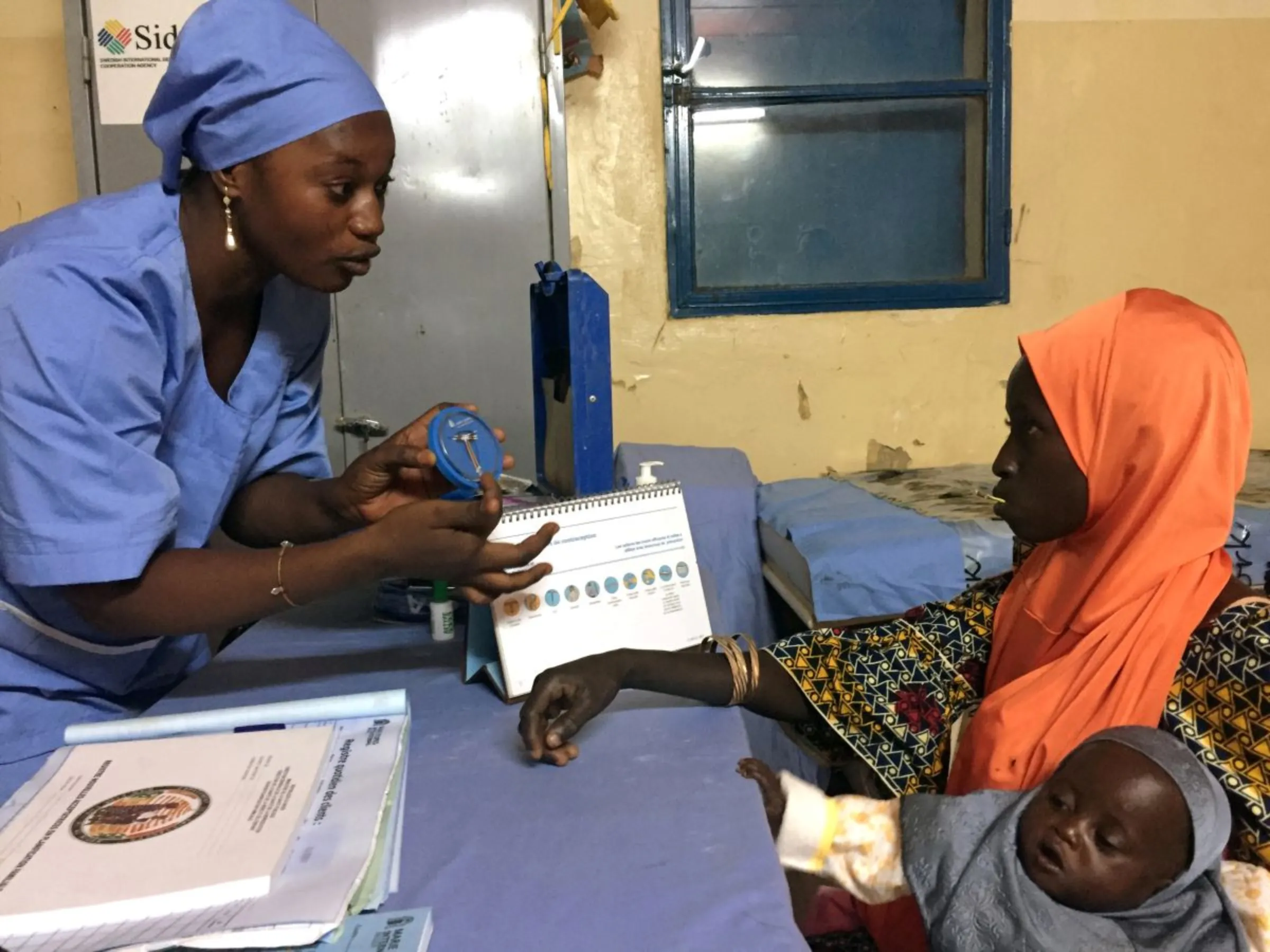 A Marie Stopes nurse explains to mother-of-three Kadidja Toudjani how a contraceptive implant works in Niger's village of Libore, about 20km southeast of the capital Niamey, Niger November 2, 2017
