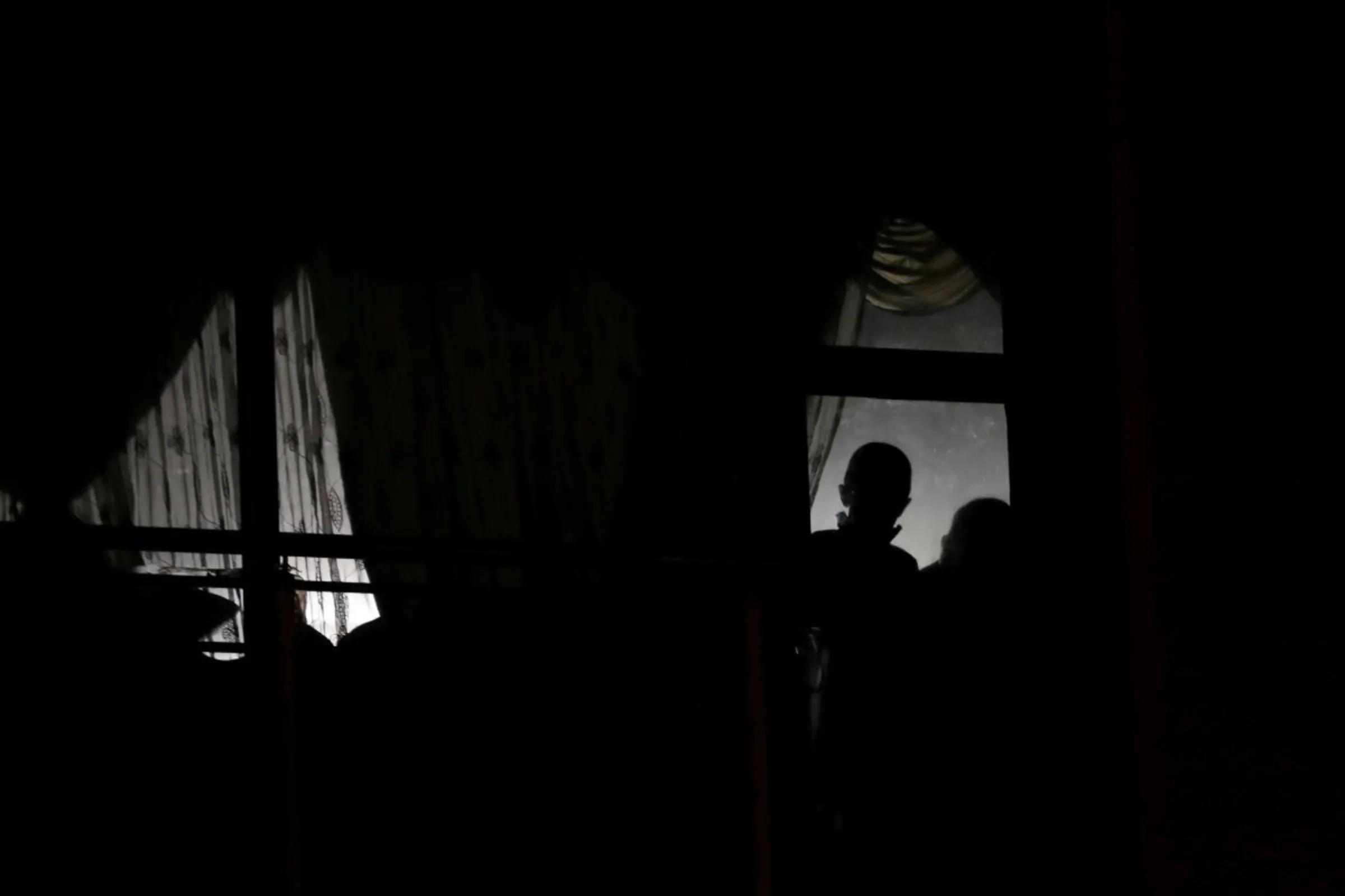 A resident looks outside the window amid a nationwide coronavirus disease (COVID-19) lockdown in Mayfair, South Africa May 1, 2020. REUTERS/Siphiwe Sibeko