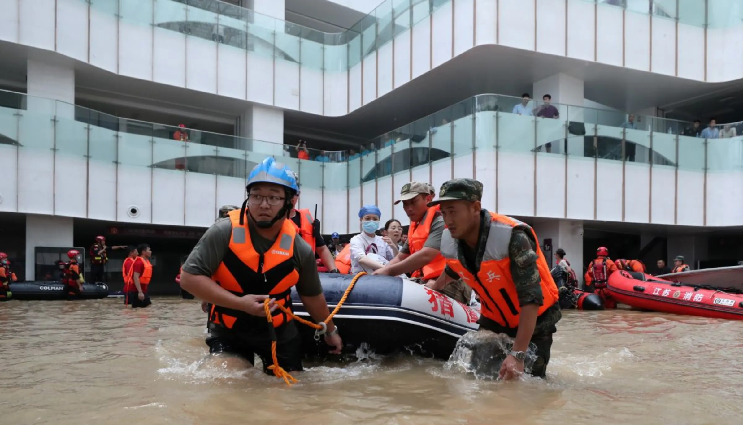 Rescue workers transfer medical workers with a boat at the Fuwai Central China Cardiovascular Hospital which was flooded following heavy rainfalls in Zhengzhou, Henan province, China July 22, 2021. China Daily via REUTERS