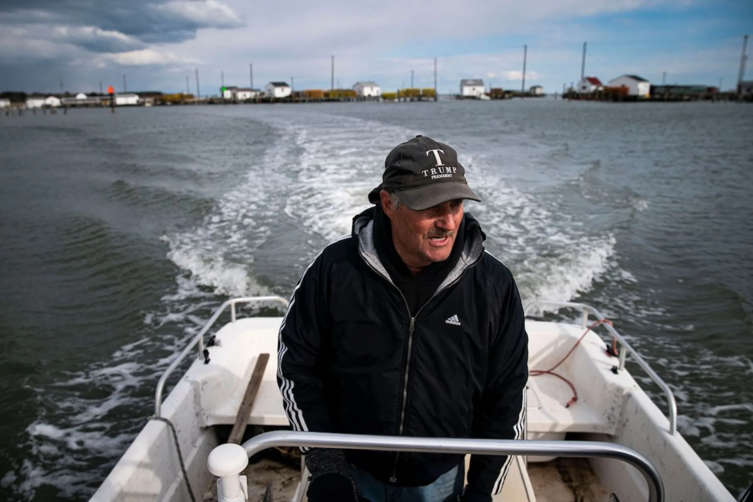 Mayor James “Ooker” Eskridge drives a boat through the harbor in the Chesapeake Bay surrounding Tangier Island, Virginia, U.S., March 28, 2022. Thomson Reuters Foundation/Al Drago
