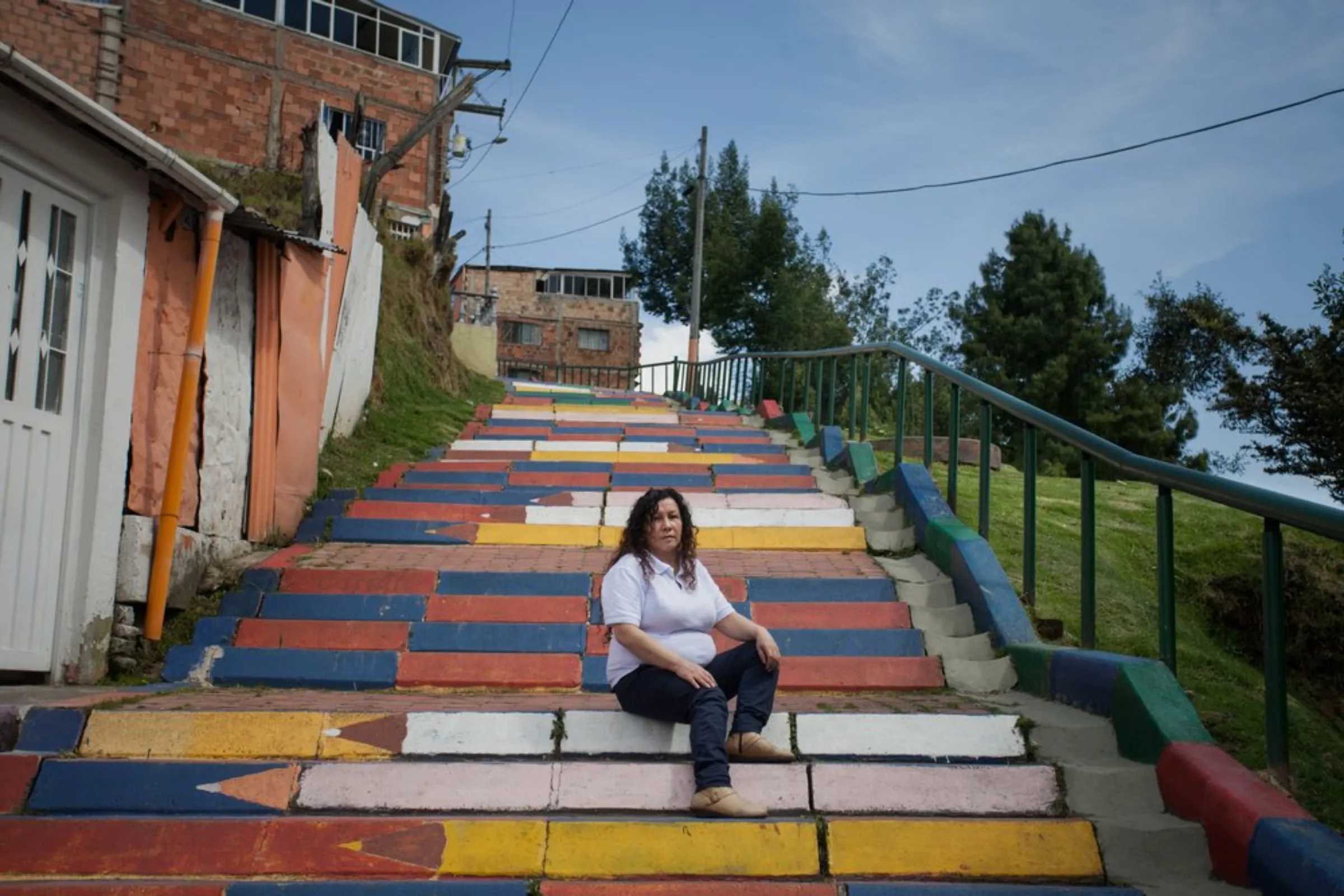 Veronica Fonseca, a community leader in Bogota’s steep San Dionisio neighbourhood, in the east of the Colombian city, sits on a set of stairs painted as coloured pencils, April 23, 2021