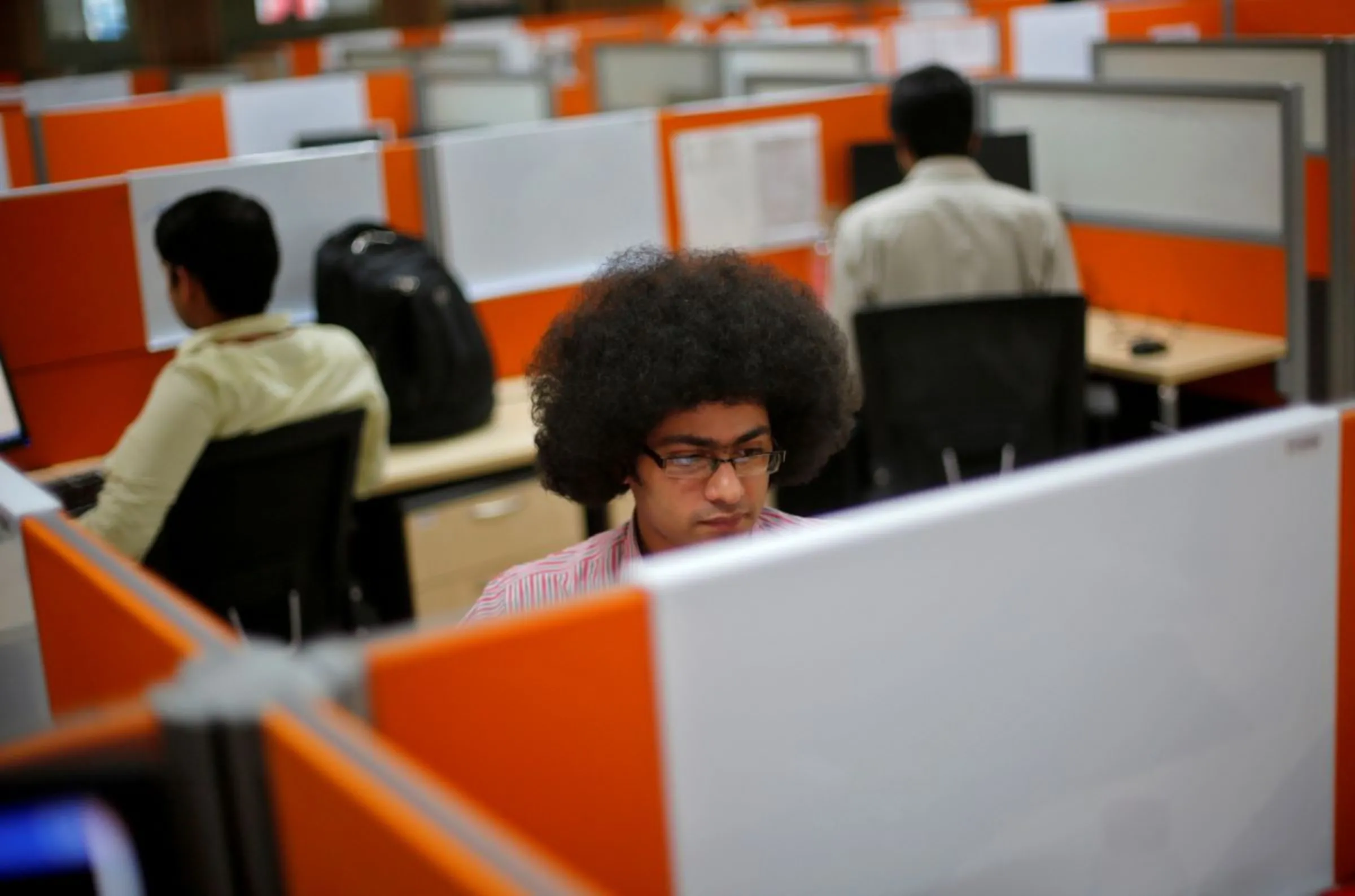 Employees work at their desks inside Tech Mahindra office building in Noida on the outskirts of New Delhi March 18, 2013. REUTERS/Adnan Abidi