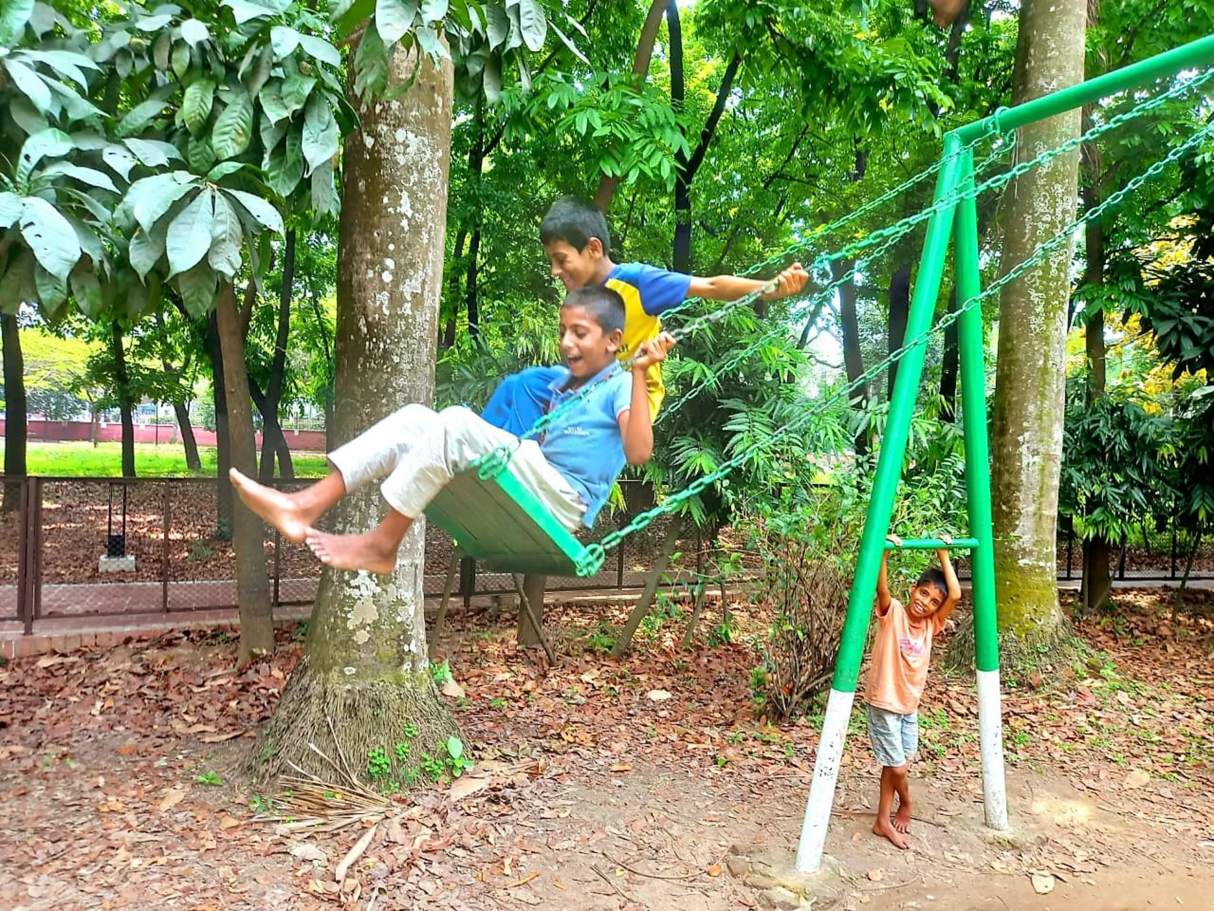 Mohammad Arif, 12 and his 10-year old brother Arafat play on a swing bench in Ramna Park after school, Dhaka, April 3, 2023, Thomson Reuters Foundation/ Md Tahmid Zami