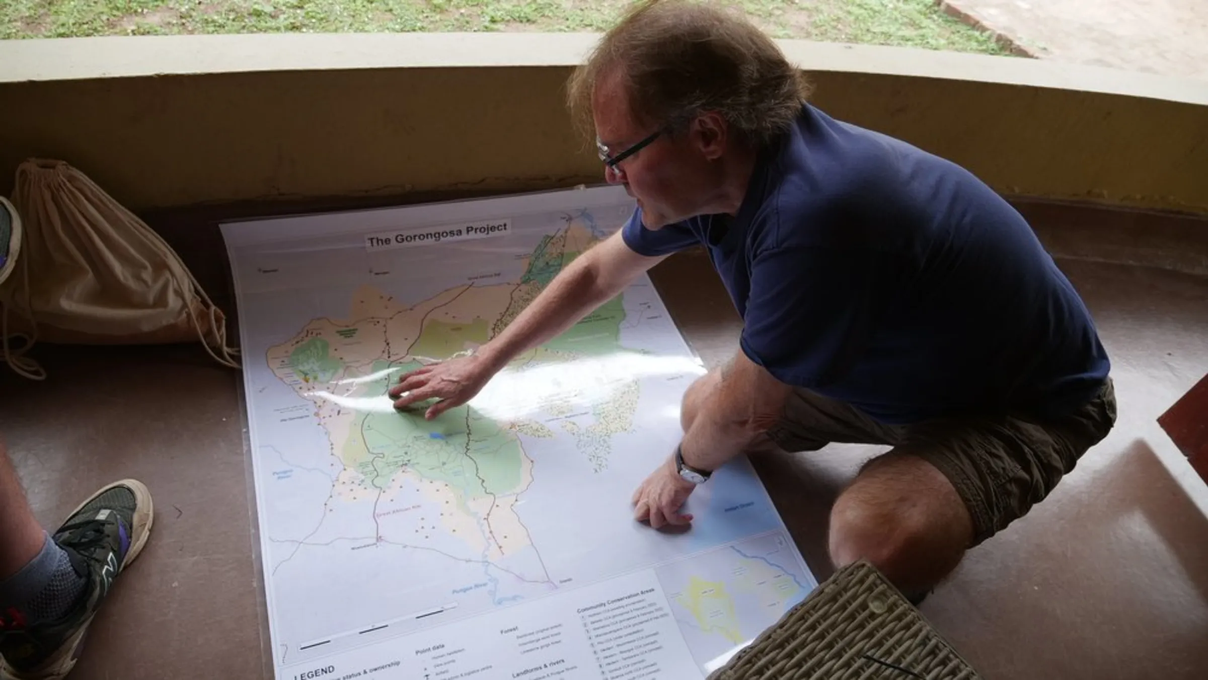 American conservationist and philanthropist Greg Carr looks at a map of Gorongosa National Park on the floor of a chalet in the Mozambican park, May 22, 2022